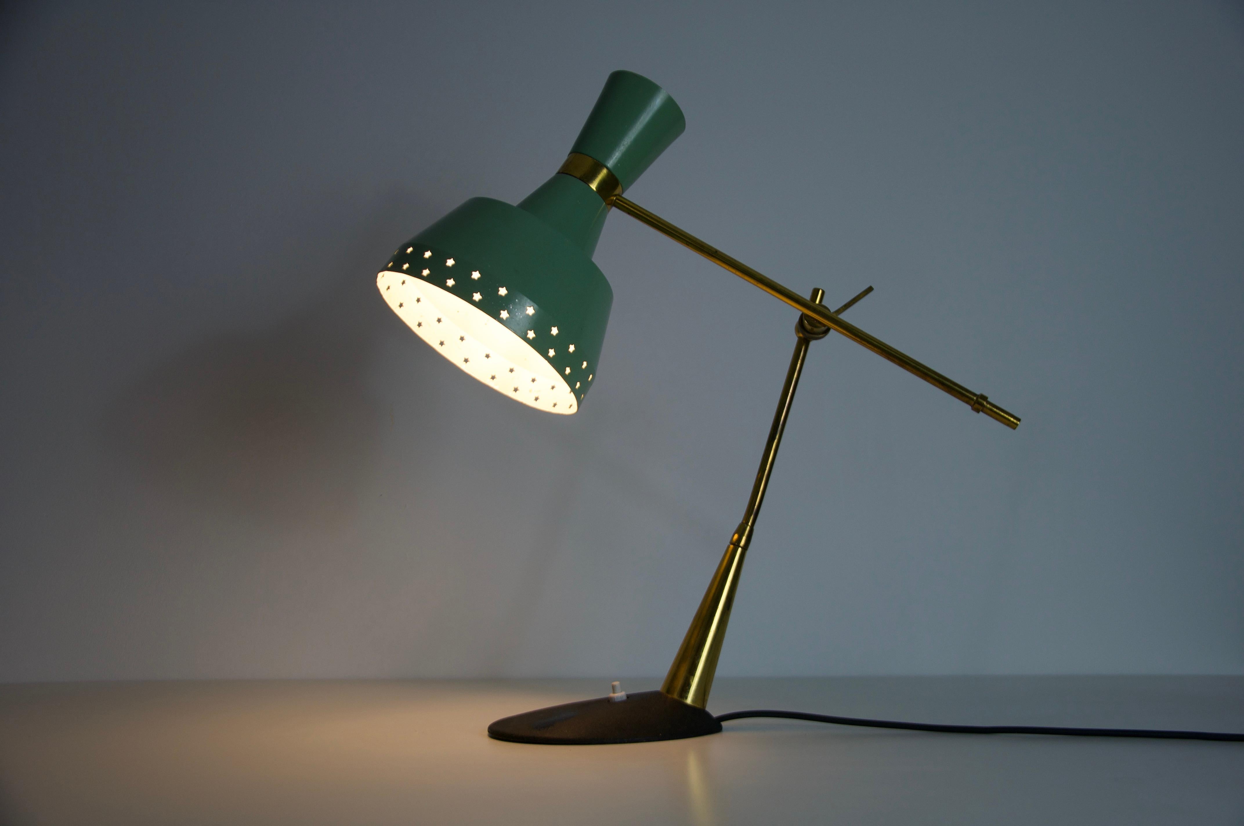 This is a stylish Mid-Century table lamp, originating from Italy and dating back to the 1960s. The lamp features a beautiful combination of brass and metal, showcasing the elegant design aesthetics of the era. The lamp's design is characterized by