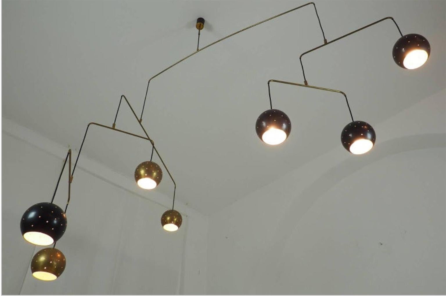 Original Italian brass mobile chandelier manufactured in a very small handcraft production in Milano, 20th century
Large, magic and poetical mobile chandelier with brass and black suspending spheres, it can moves with the flow of air.
Wholly in