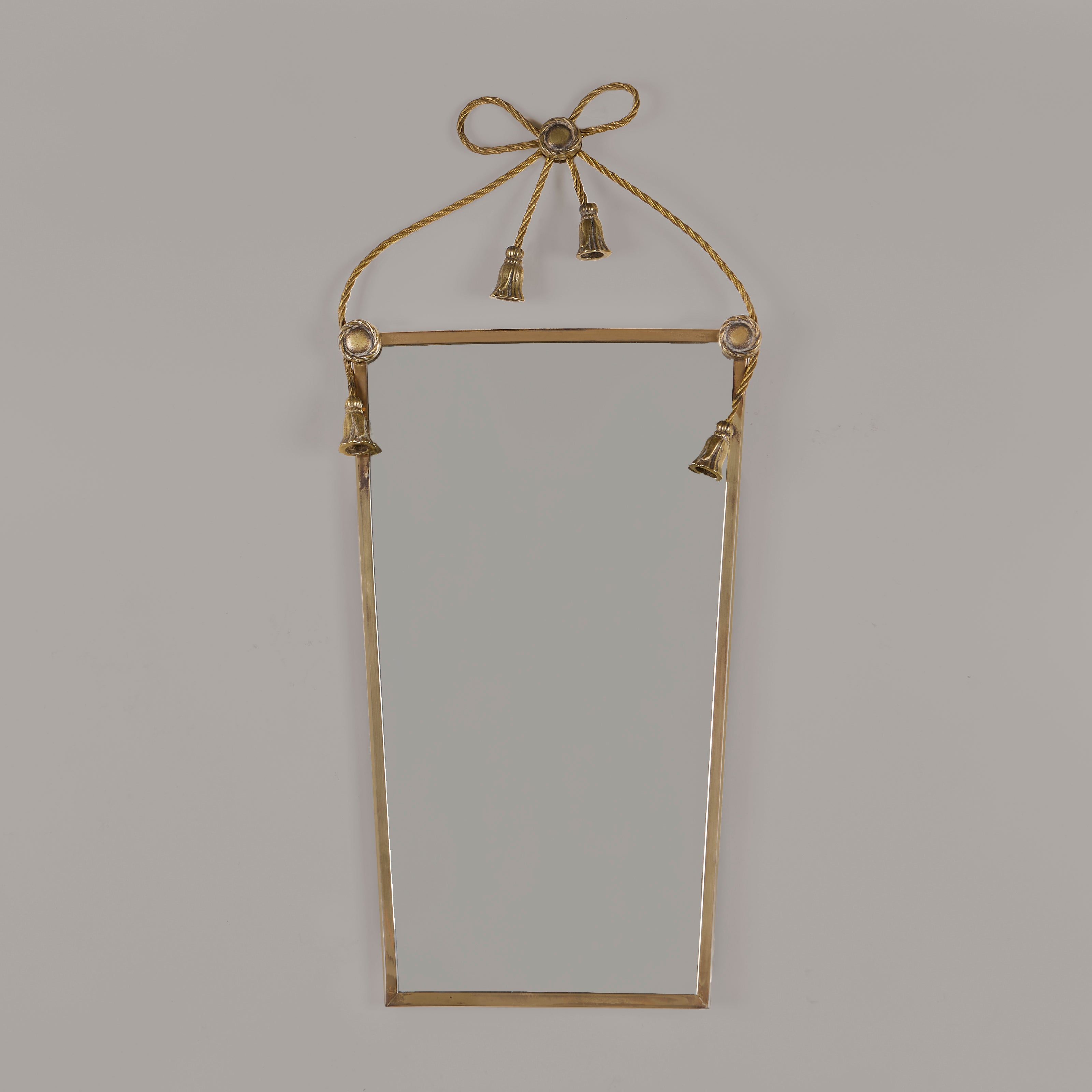 Italian brass rectangular mirror with surrealist twisted metal to form trim, bow, knot and draped tassels.