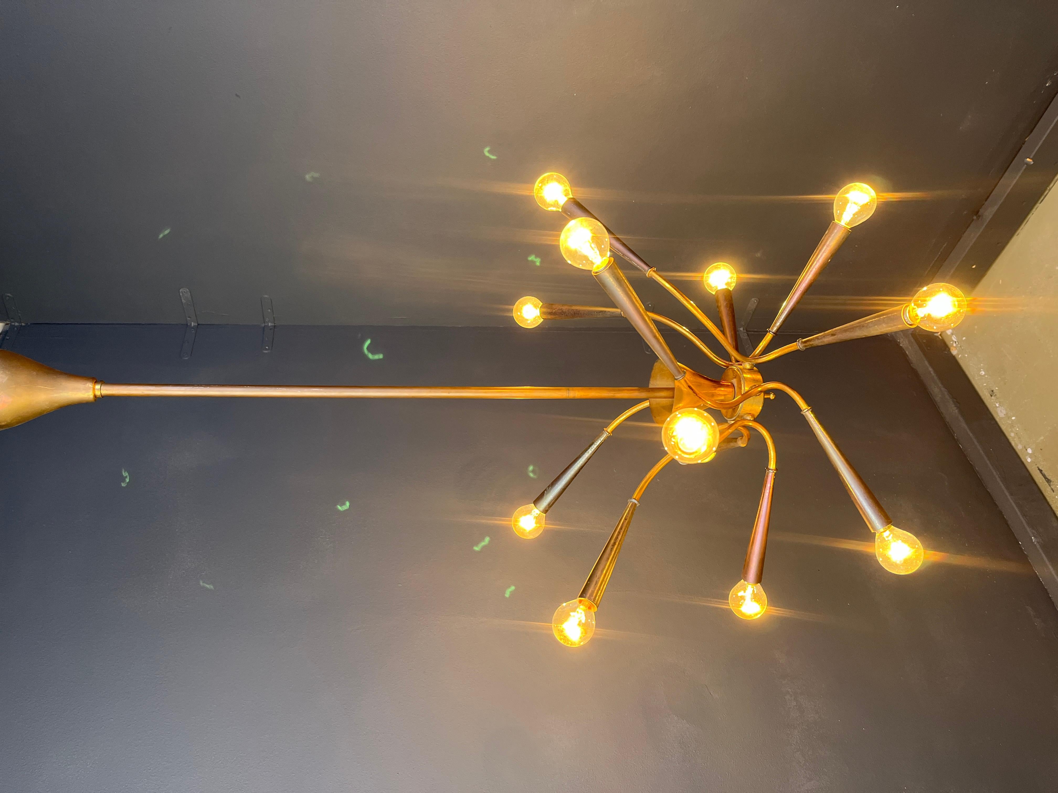 Mid century brass chandelier with bent arms and 12 lightpoints.

Sturdy metal conical light bulb holders.

Attributed to Oscar Torlasco.

tested and ready to use with E14 light bulbs.

Good condition, beautifully patinated brass

1960s -