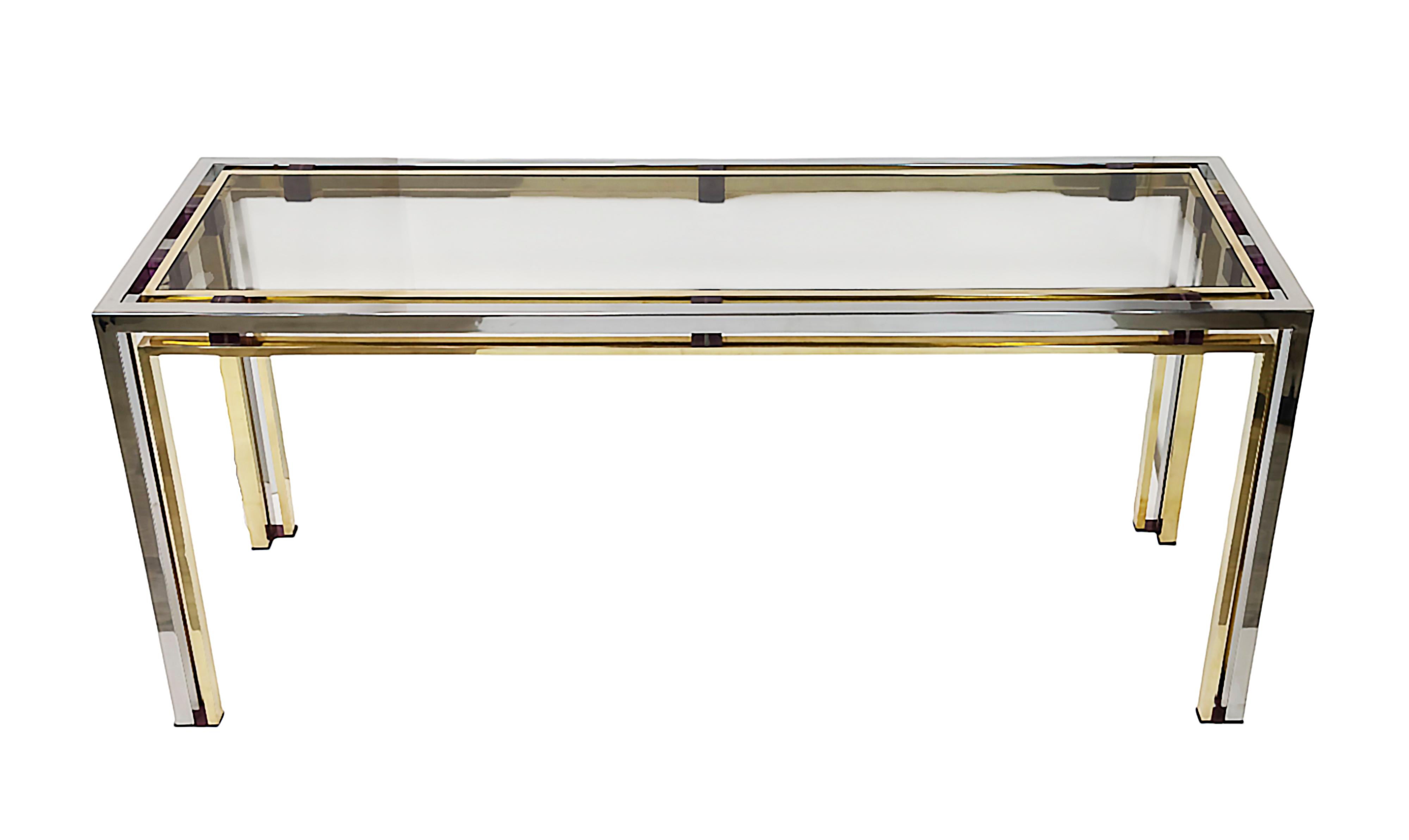 Cette grande table console italienne du milieu du siècle en laiton et structure chromée avec plateau en verre fumé a été réalisée par Romeo Rega dans les années 1970. 
Le cadre est décoré de détails en plexiglas de couleur violette sur le dessus et