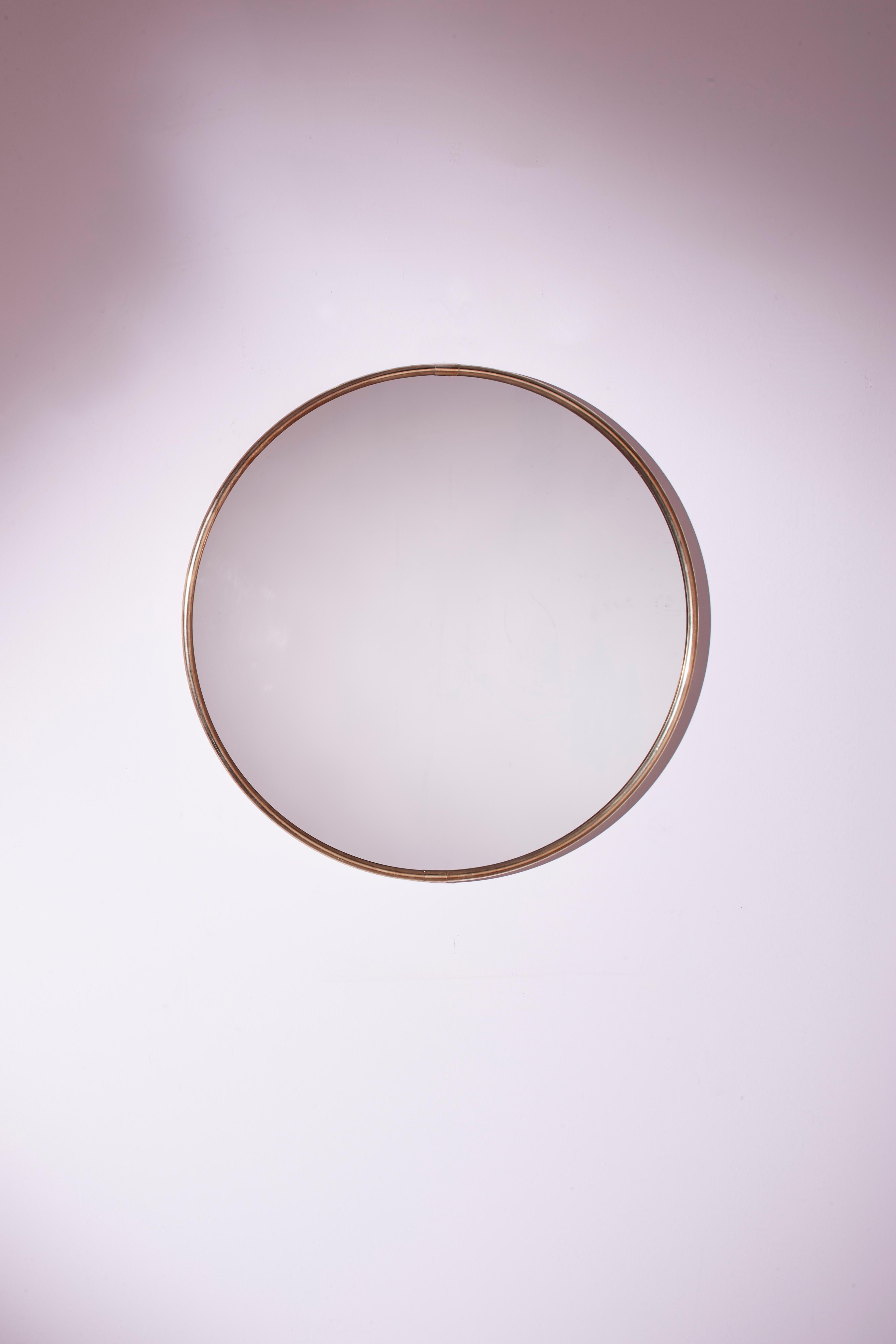 A charming circular mirror of Italian craftsmanship dating back to the seventies, characterized by an original reflective plate and a thin brass frame.

This refined piece of furniture is perfect for enhancing the entrance, bedroom, or bathroom,