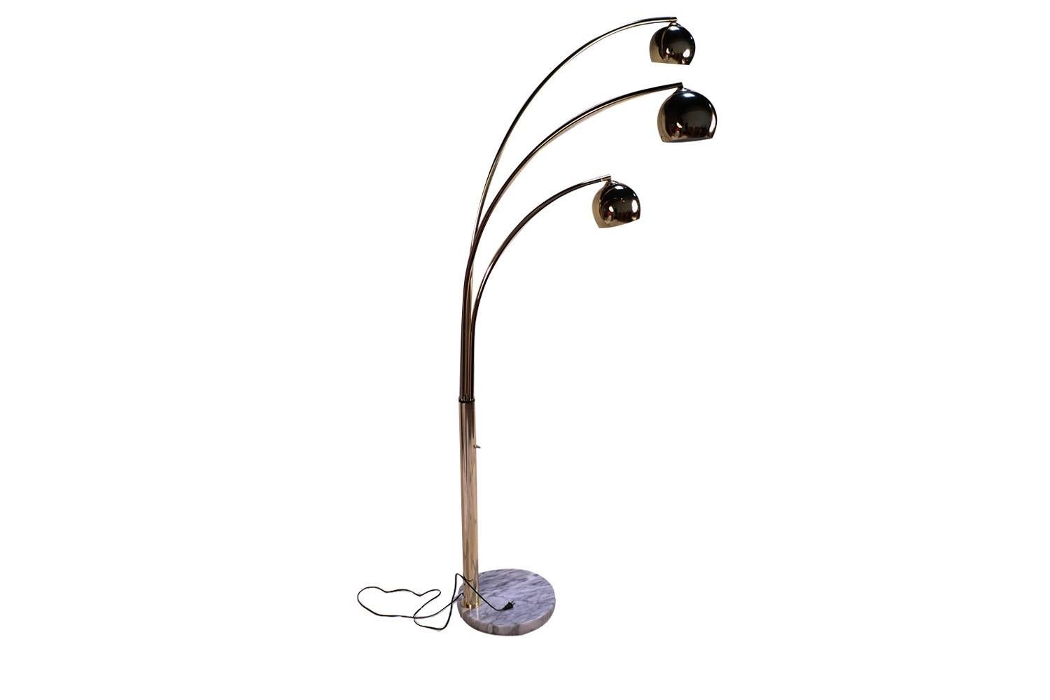 Stunning monumental arc 3 arm floor lamp, circa 1970s, designed in the manner of Italian designer Castiglioni. Features three brass spherical shades atop three independently, swivel brass cantilever rods, supported by a beautiful thick, white veined
