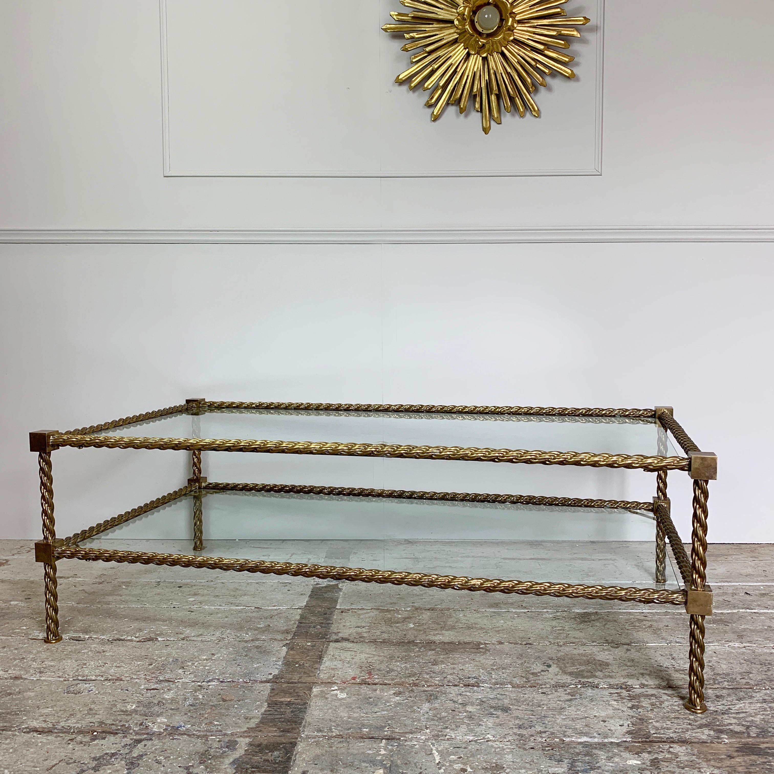 Italian brass rope coffee table
midcentury circa 1960s-1970s
A high quality solid brass twisted rope detail base with 2 glass shelves
The shelves rest on brass rods at each corner
The glass panels are shaped at the corners to fit the table