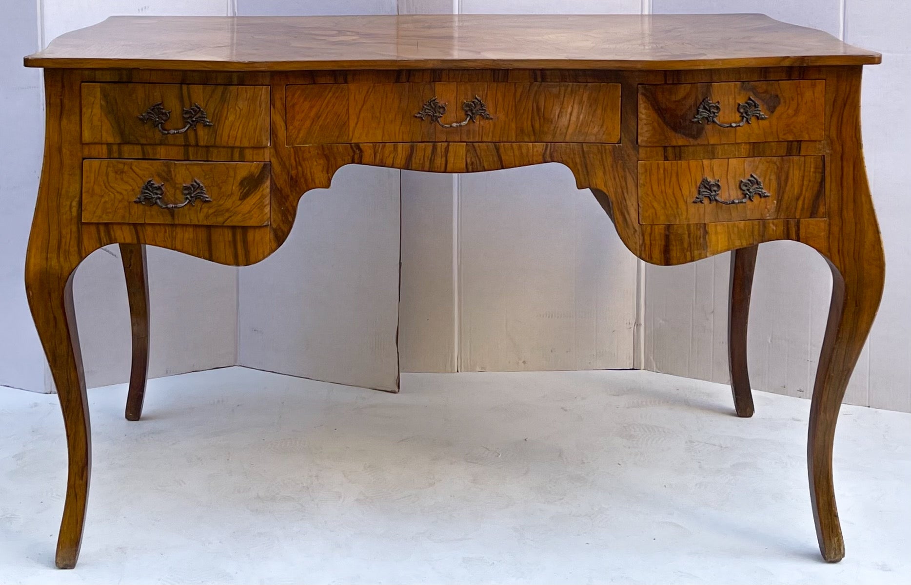 This is a killer piece! It is a mid-century Italian burl wood and olive wood serpentine desk. It is in very good condition. It is marked in several places that it was made in Italy. Note the beautiful lines throughout the piece! Floor to drawer is