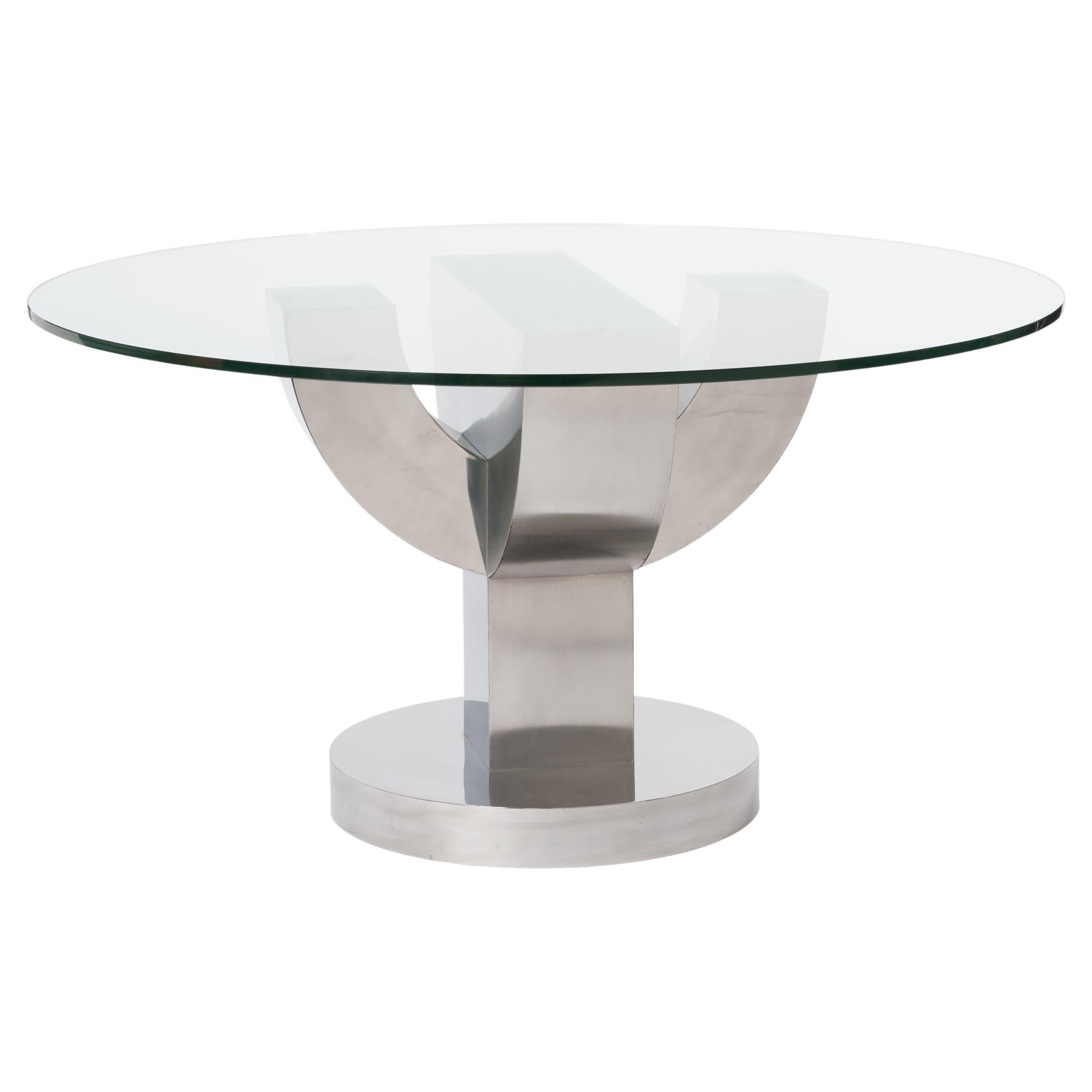 Exceptional round dining table with thick glass top and solid wood base, veneered with stainless steel. 
The stainless steel pallet veneer finish consists of alternating matte and shiny sections, giving the table a particularly striking