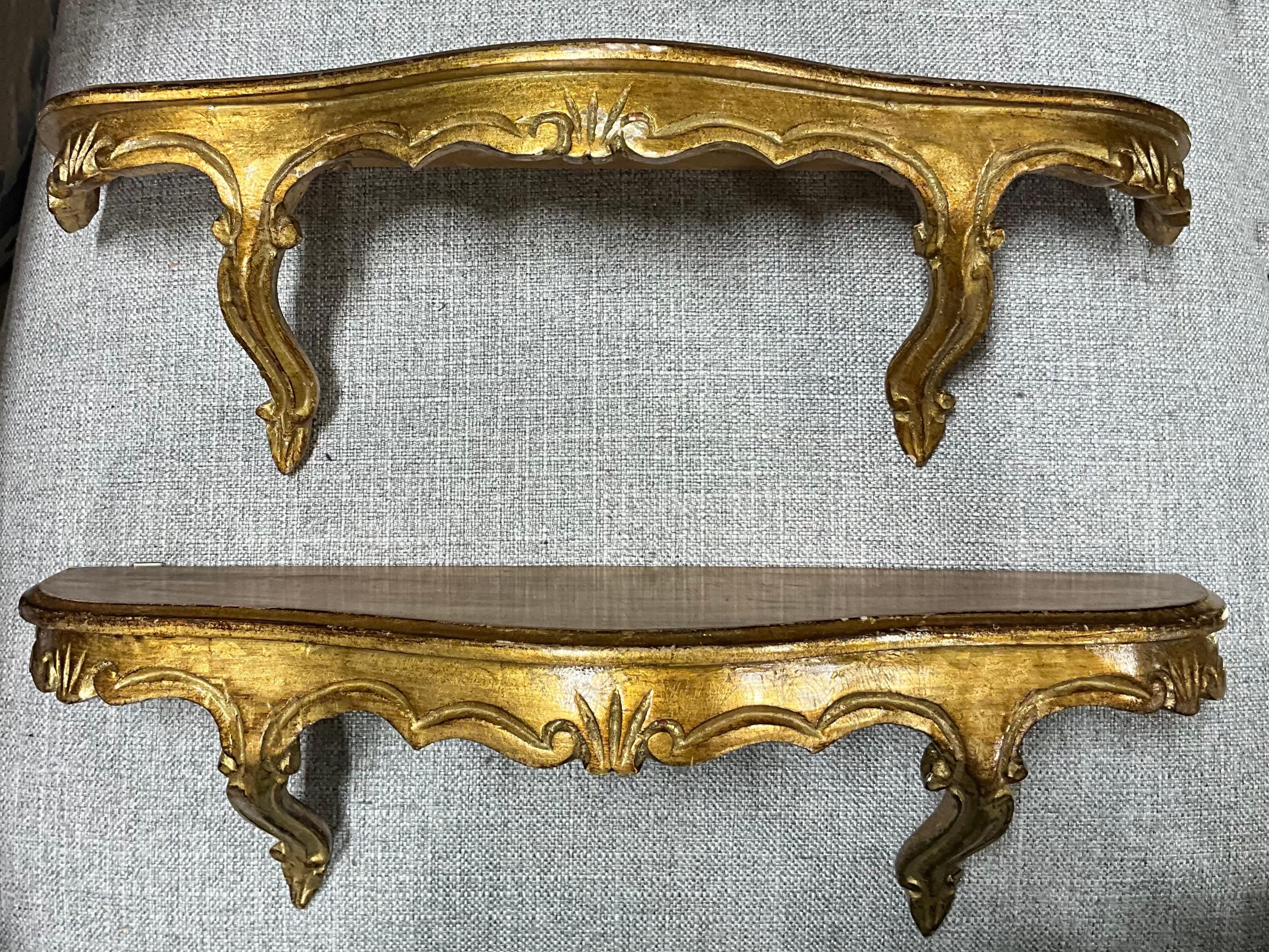 This is a diminutive pair of Italian carved giltwood Rococo style wall shelves or brackets by Decorative Crafts. They are poplar and an unusual size. The shelves are in very good vintage condition.
