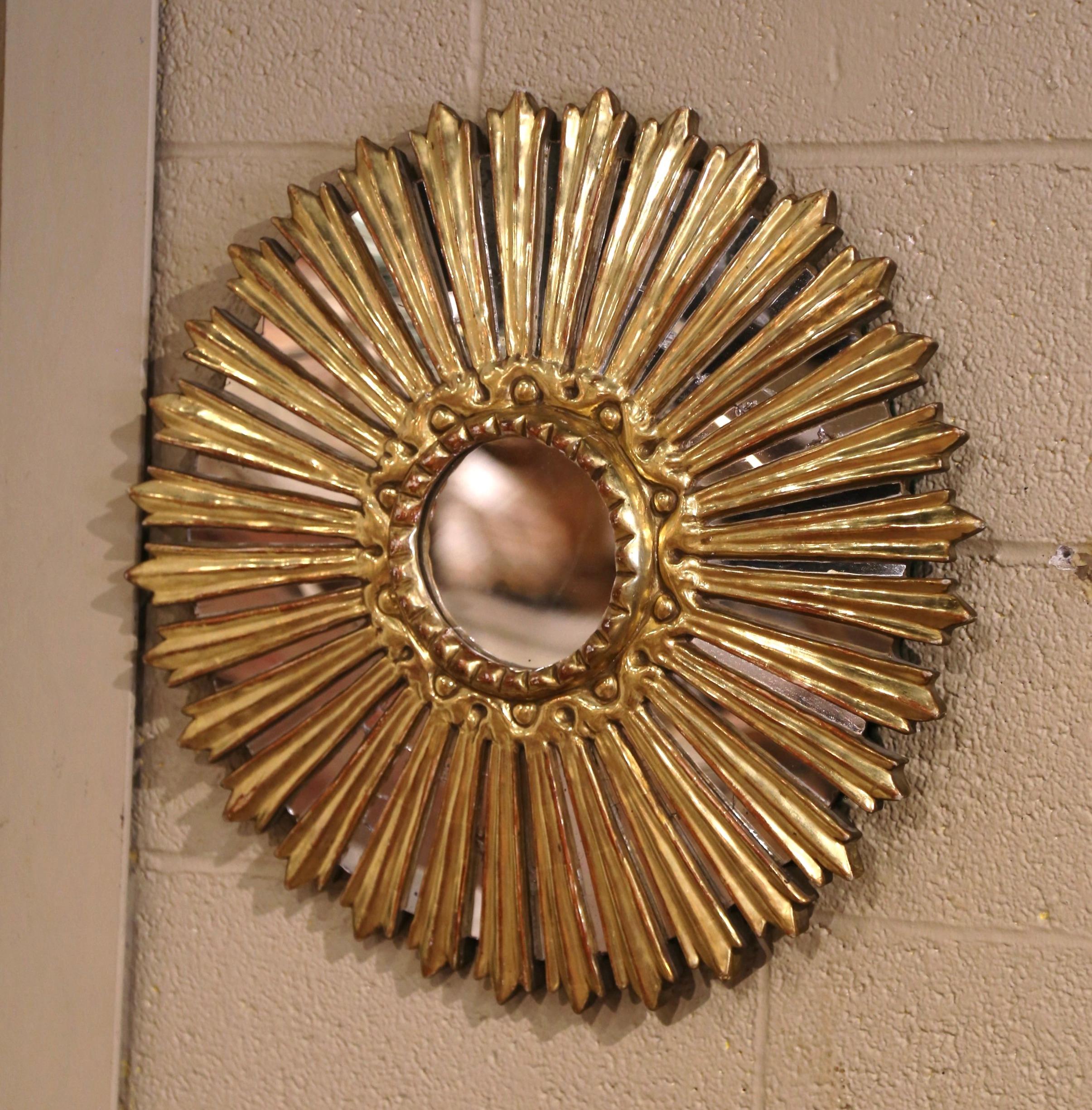 Aporta un toque radiante a tu hogar con este llamativo espejo de madera dorada con efecto sol. Tallada a mano en Italia hacia 1970, esta decoración de pared vintage en forma de sol presenta un espejo central circular, enmarcado por inserciones