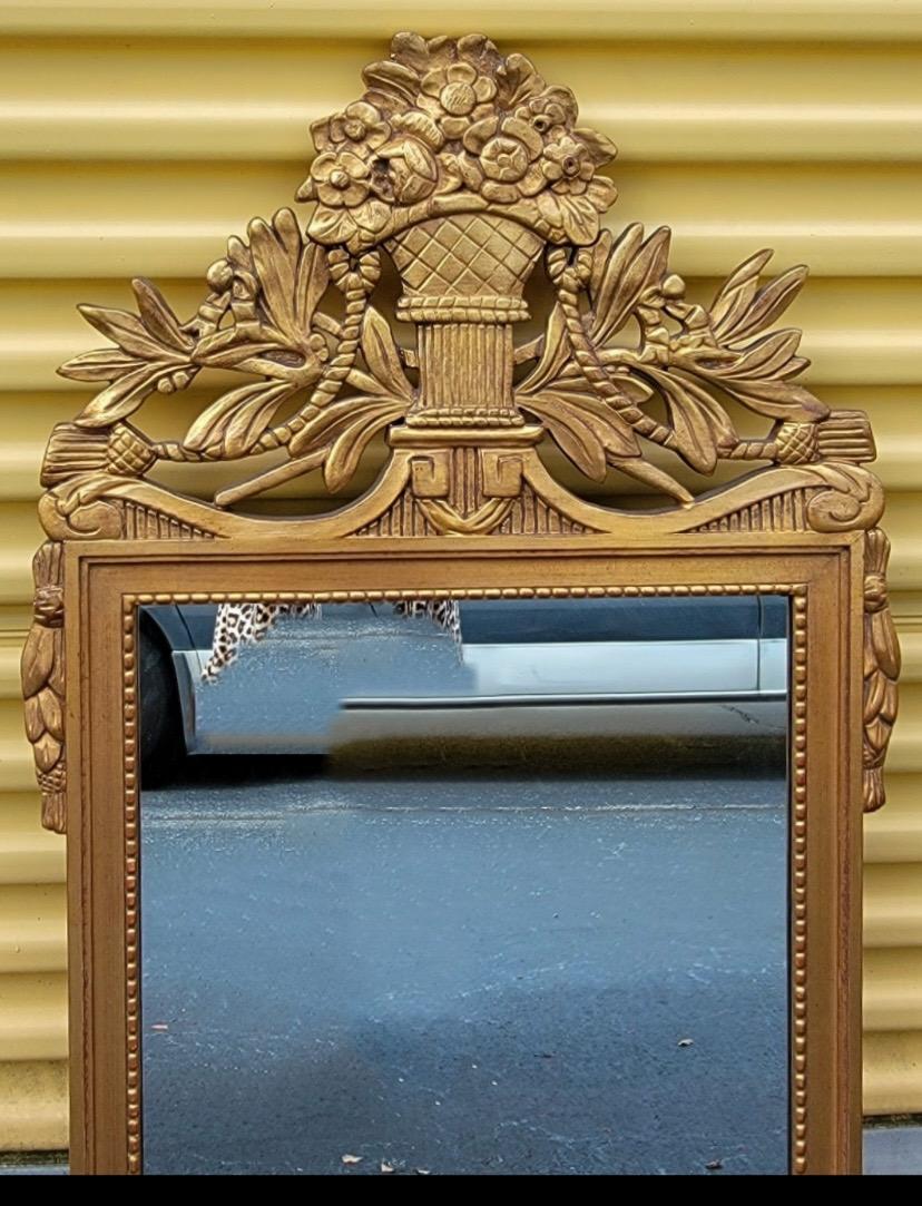This is an Italian carved giltwood mirror with French styling. It is in very good condition. The mirror is unmarked. The style is in the manner of an antique Louis XIV piece.