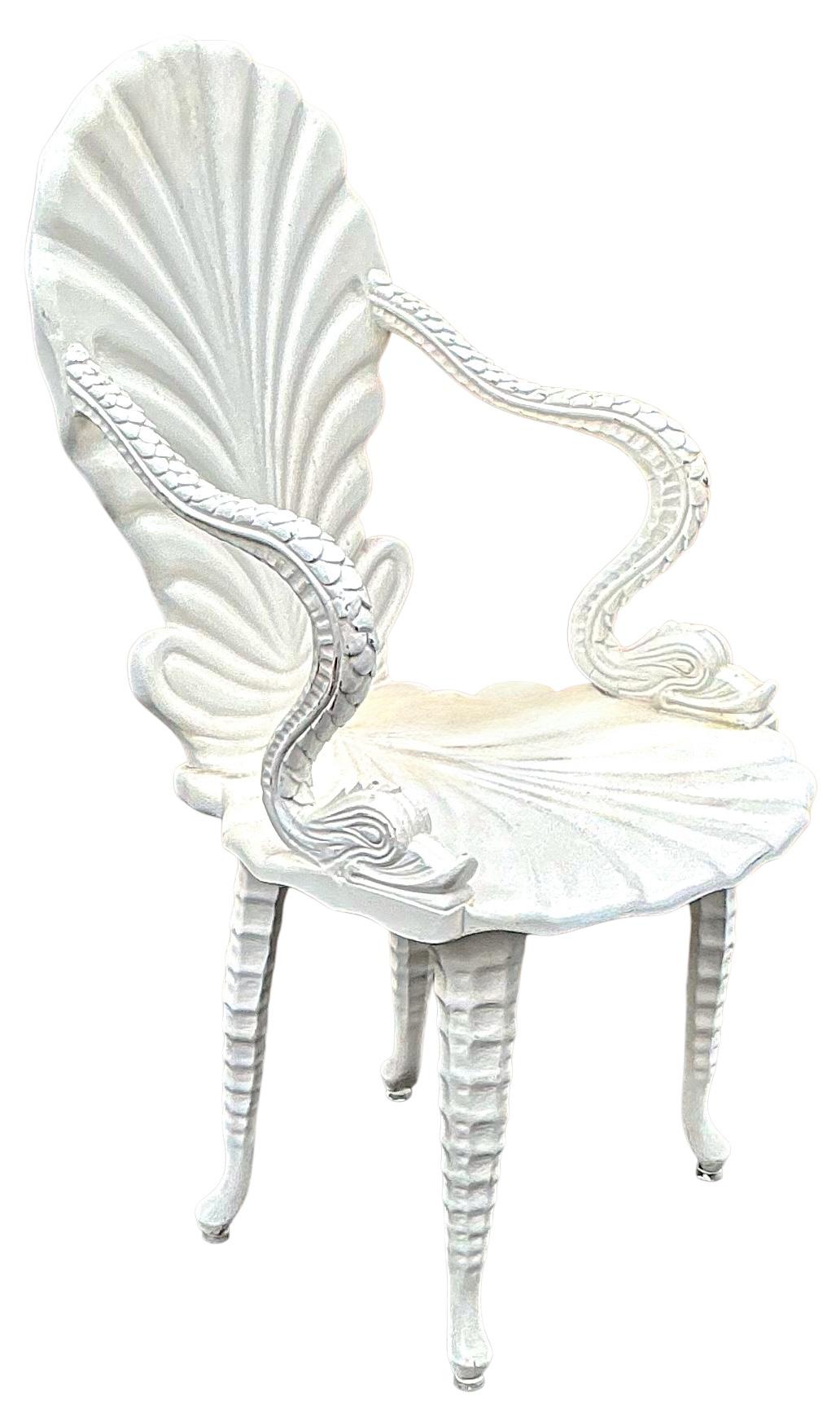 This is a fun chair! It is a mid-century white lacquered shell form grotto chair with carved dolphin / serpent arms and leg supports. The white lacquered finish is a vintage finish. It is Italian. Pardon the slight reflection on one side. The