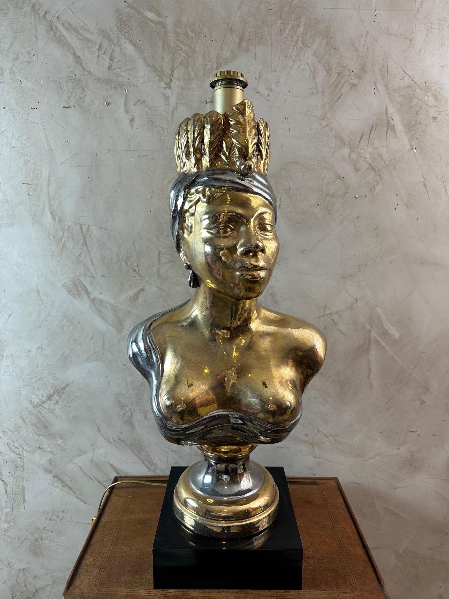 Magnificent and rare large lamp in gold and silver ceramic dating from the 60s representing an African woman with naked breasts and dressed with a beautiful hairstyle. Very elegant. Large white lampshade with gold and silver braid finish. Black