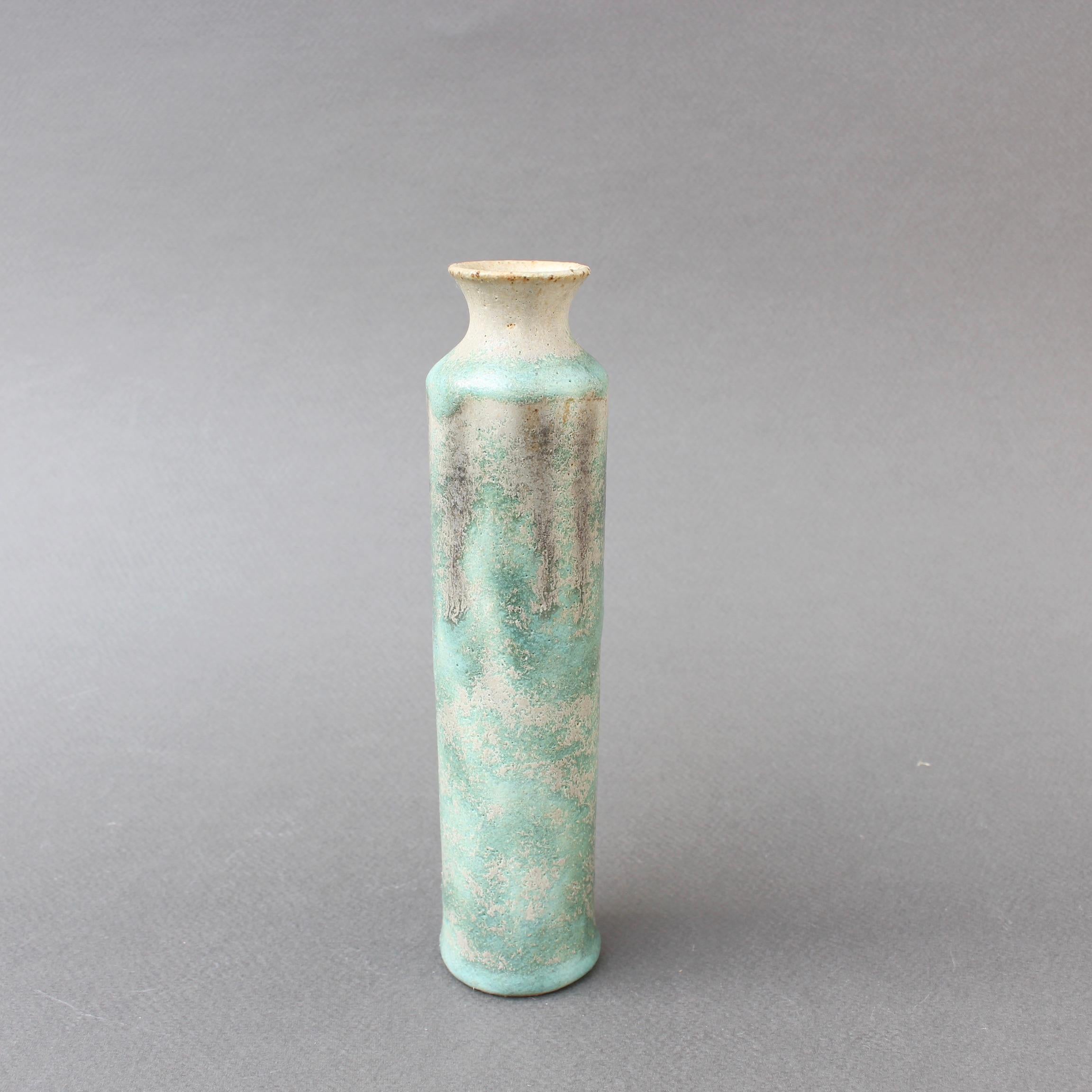 Diminutive midcentury Italian ceramic bottle by Bruno Gambone (circa 1970s). Elegantly cylindrical with a misty, rustic, matt glaze in an aqua green, patches of beige and several dark stripes evincing dripping spray paint rather than a more