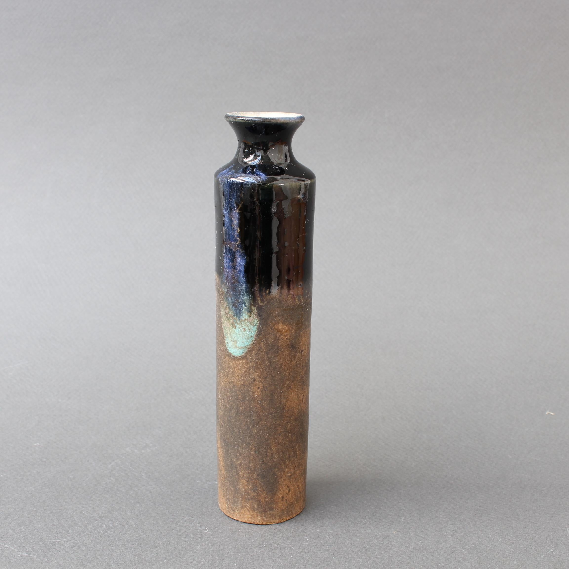 Diminutive midcentury Italian ceramic bottle by Bruno Gambone (circa 1970s). Elegantly cylindrical with a two-toned glaze, one glossy black, the other below, muted and matt in chocolate brown. Its form is reminiscent of ancient storage vessels from
