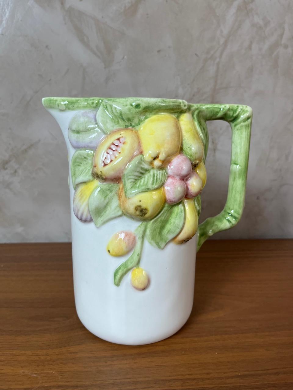 Encantadora jarra de cerámica esmaltada, fabricada en Italia, con un diseño en relieve de frutas de colores. Una pieza llena de carácter, perfecta para la decoración de una cocina mediterránea, un interior de estilo vintage o el uso diario.