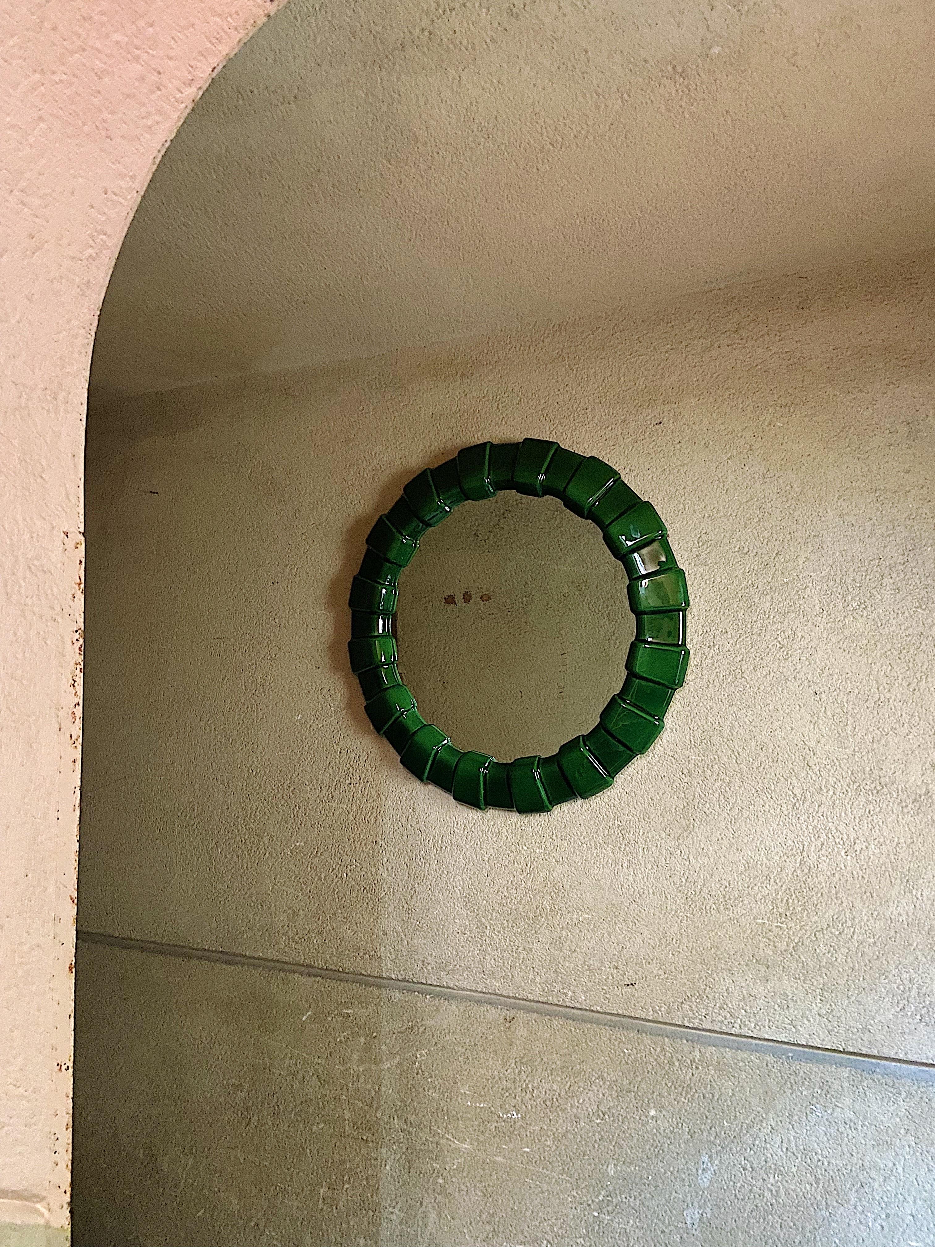 Very beautiful ceramic wall mirror. Extraordinary design with its round and in the same time irregular shape made of ceramic coloured in emerald green.

Manufactured in the 1970s.

Very elaborately processed with many beautiful details.

Good