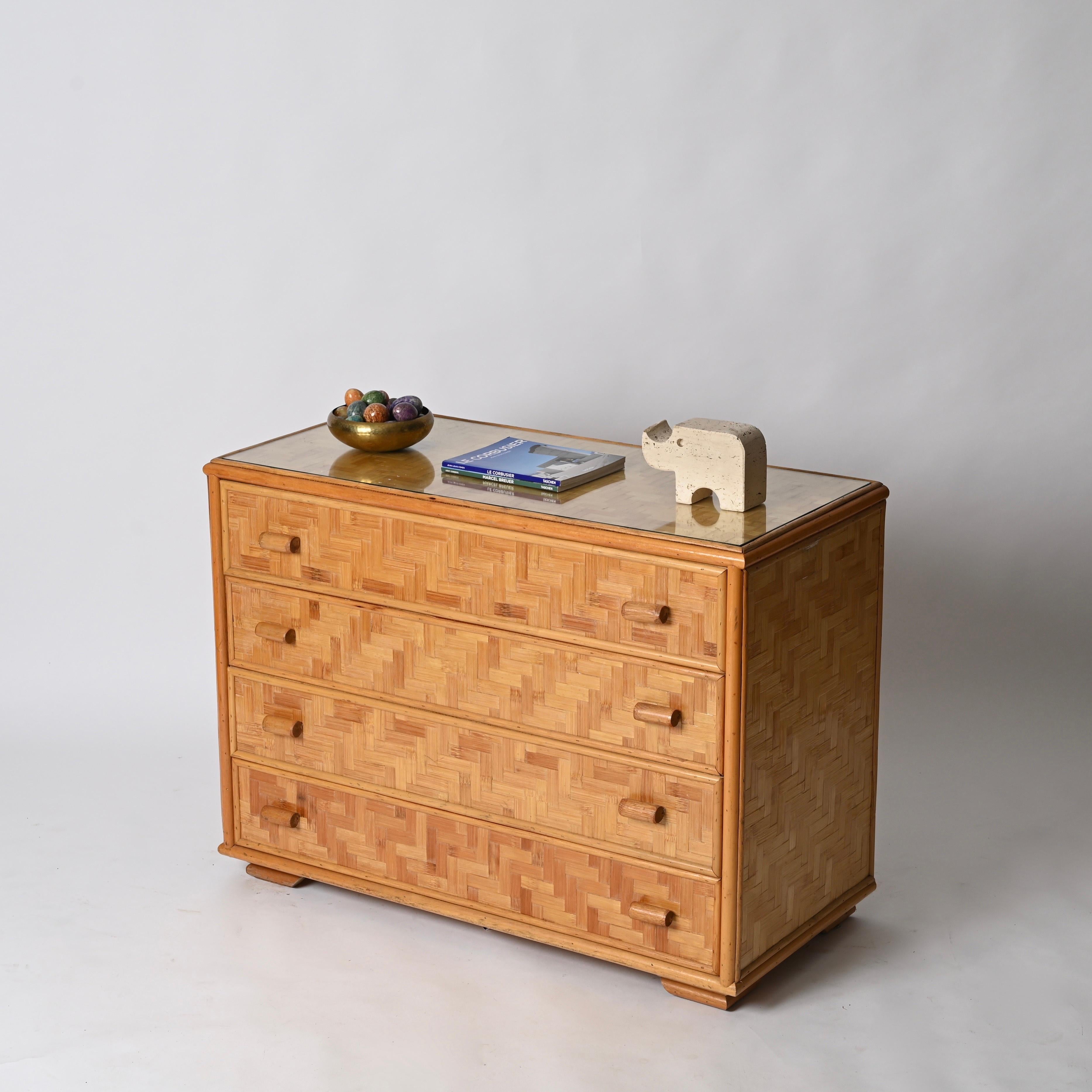 Splendida cassettiera della Costa Azzurra di metà secolo, completamente realizzata in rattan e bambù e completata da un piano in cristallo. Questa elegante cassettiera organica è stata realizzata a mano in Italia negli anni Settanta.

In condizioni