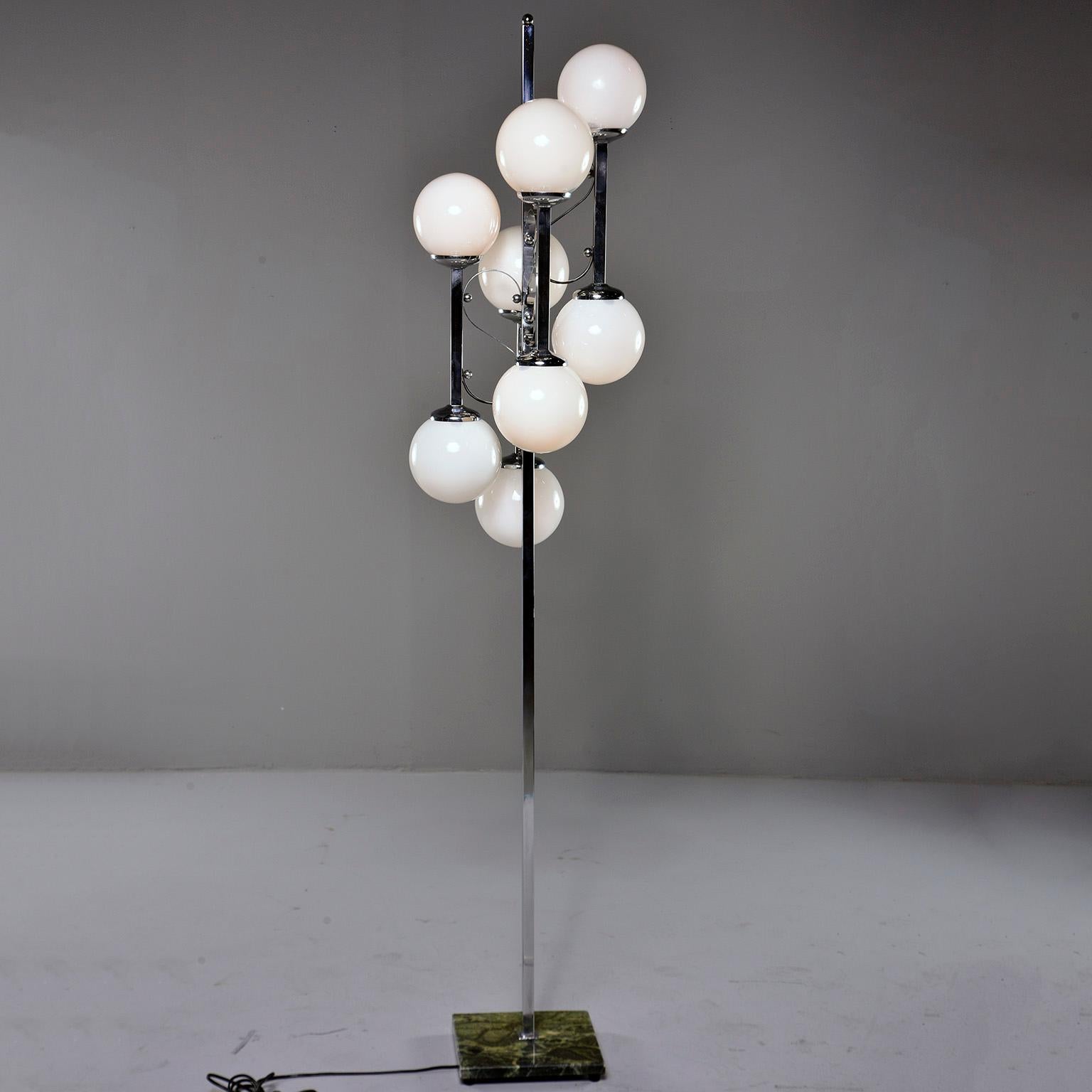 Italian floor lamp has a green marble base with polished chrome center support with four arms and eight white glass globes with candelabra sized sockets, circa 1970s. Unknown maker. New wiring for US electrical standards.