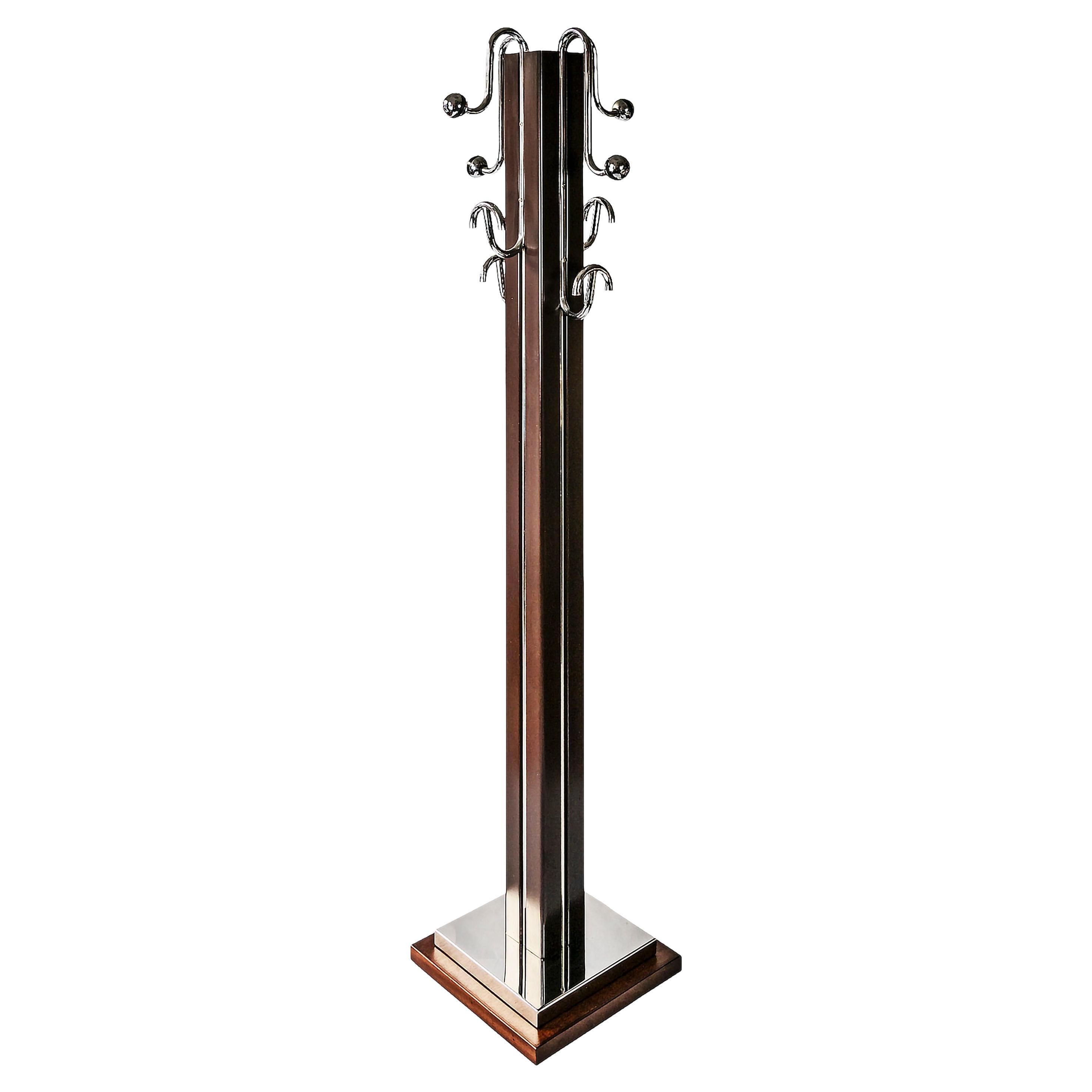 Mid-Century Italian coat rack/stand is made of wood and chrome metal details.
It's rectangular form base is wooden with the chrome frame.
The vertical body is in colored metal.
Heavy and stable.
Very good/excellent vintage condition.