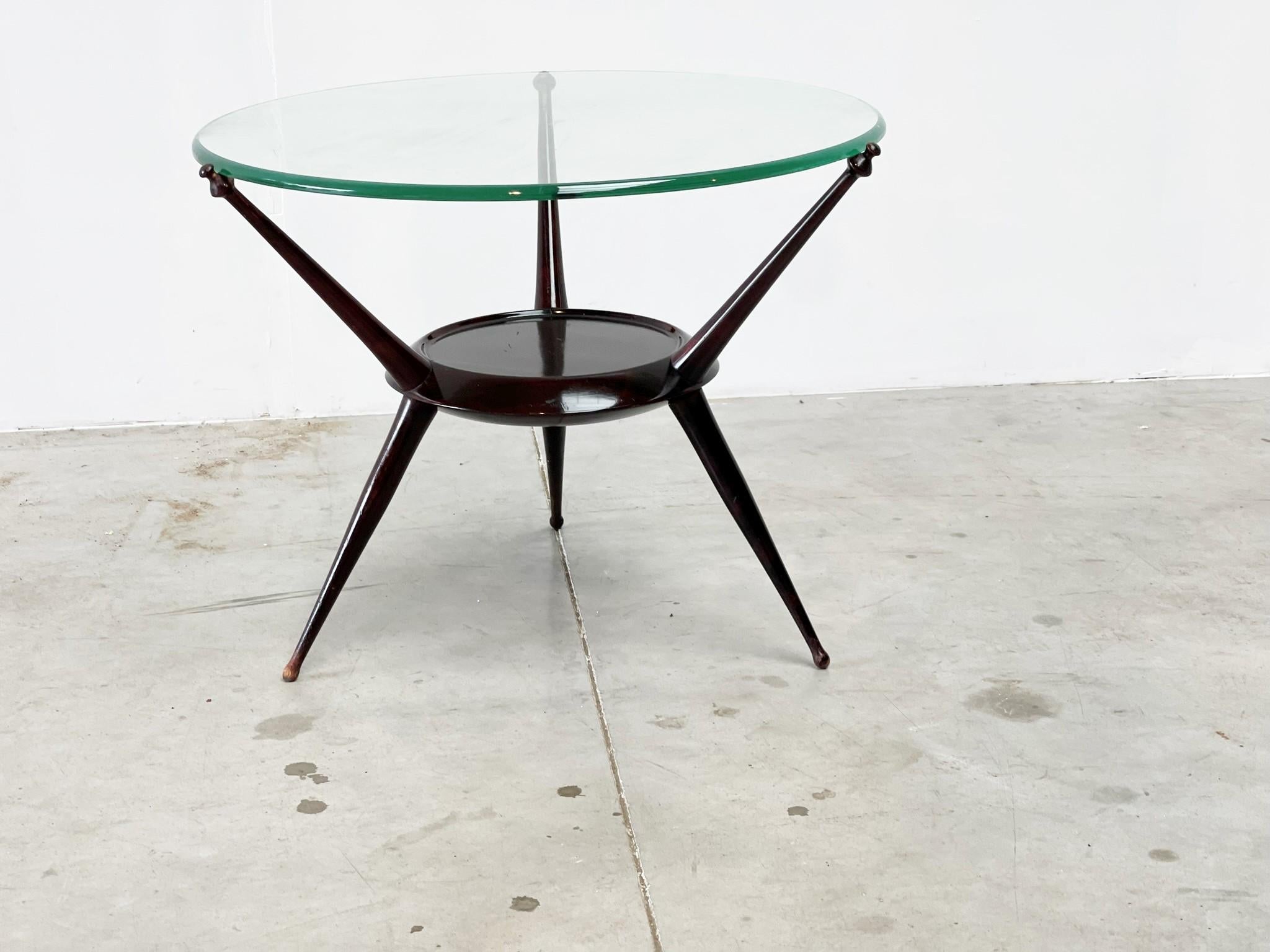 Elegant mid century tripod coffee table. Beautiful very dark brown table base with a nice clear glass round top.

Beautifully crafted table legs.

1950s - Italy

Good condition

Dimensions:
Widt: 65cm/25.59