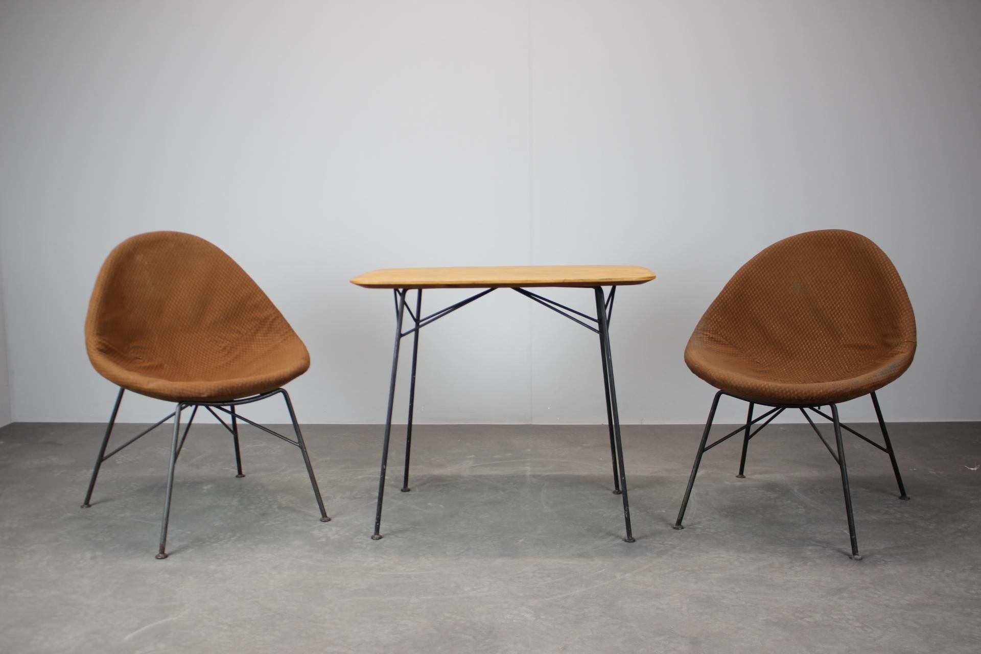 A mid-century Italian seating ensemble from the 1960s, composed of a coffee table with a sanded wooden top treated with clear bio oil and oak stain, paired with two sculptural lounge chairs. The chairs retain their original upholstery, and both
