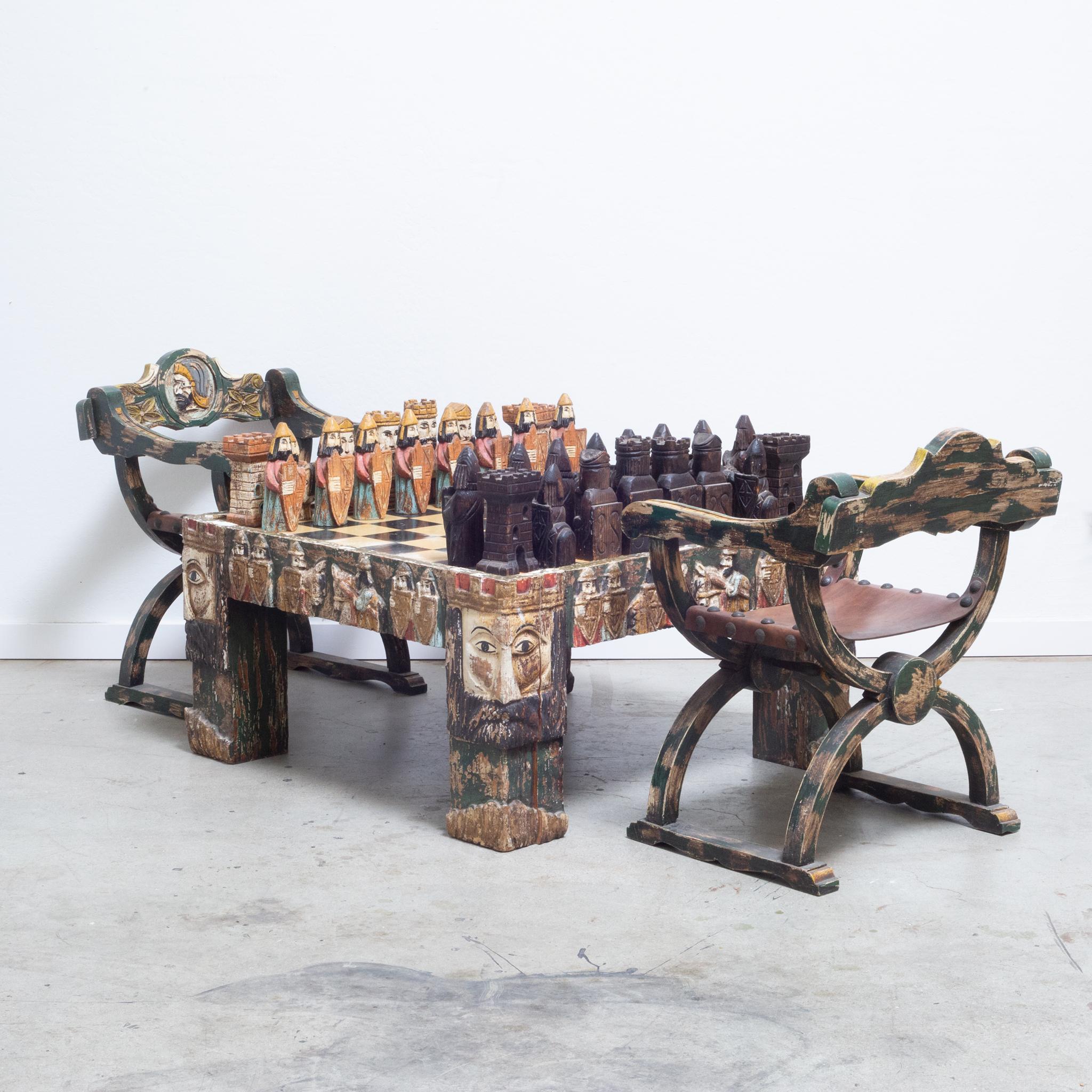 European Medieval style carved and polychromed chess table and game pieces,
Together with a like motif pair of curule chairs.

Mid-century chess coffee table, chess set and matching chairs. Italian polychrome and gesso hand carved coffee table with