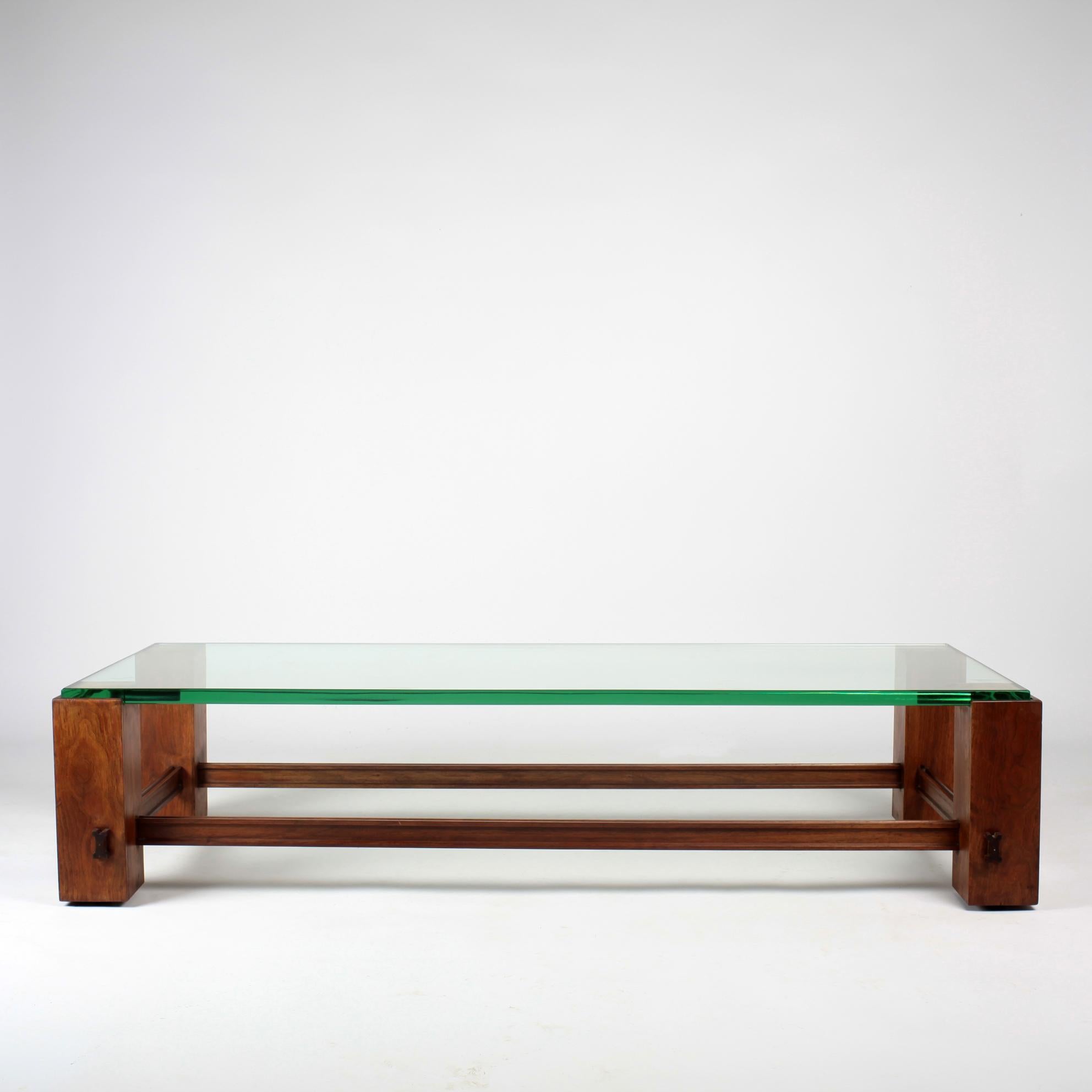 Stunning wooden coffee table with a very thick glass top. Italian work attributed to Fontana Arte from the 1950s, certainly a special order. Beautiful dimension with its 1m 40 in length.