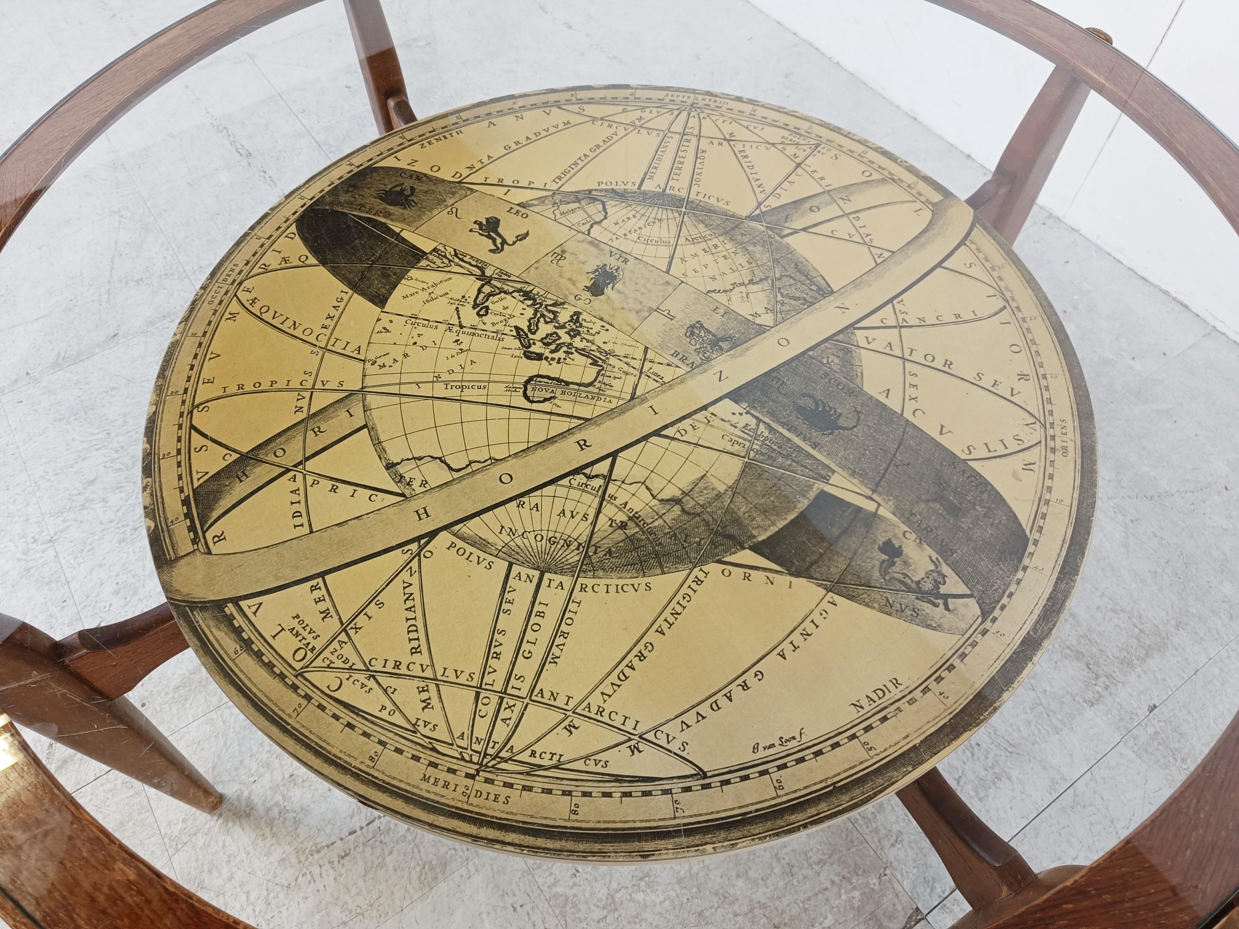 Mid century round coffee table consisting of a nicely crafted wooden frame, a clear glas top and a antique world map table top.

Very much in the style of Piero Fornasetti.

1950s - Italy

Good condition

Dimensions:
Widt: 105cm/41.33