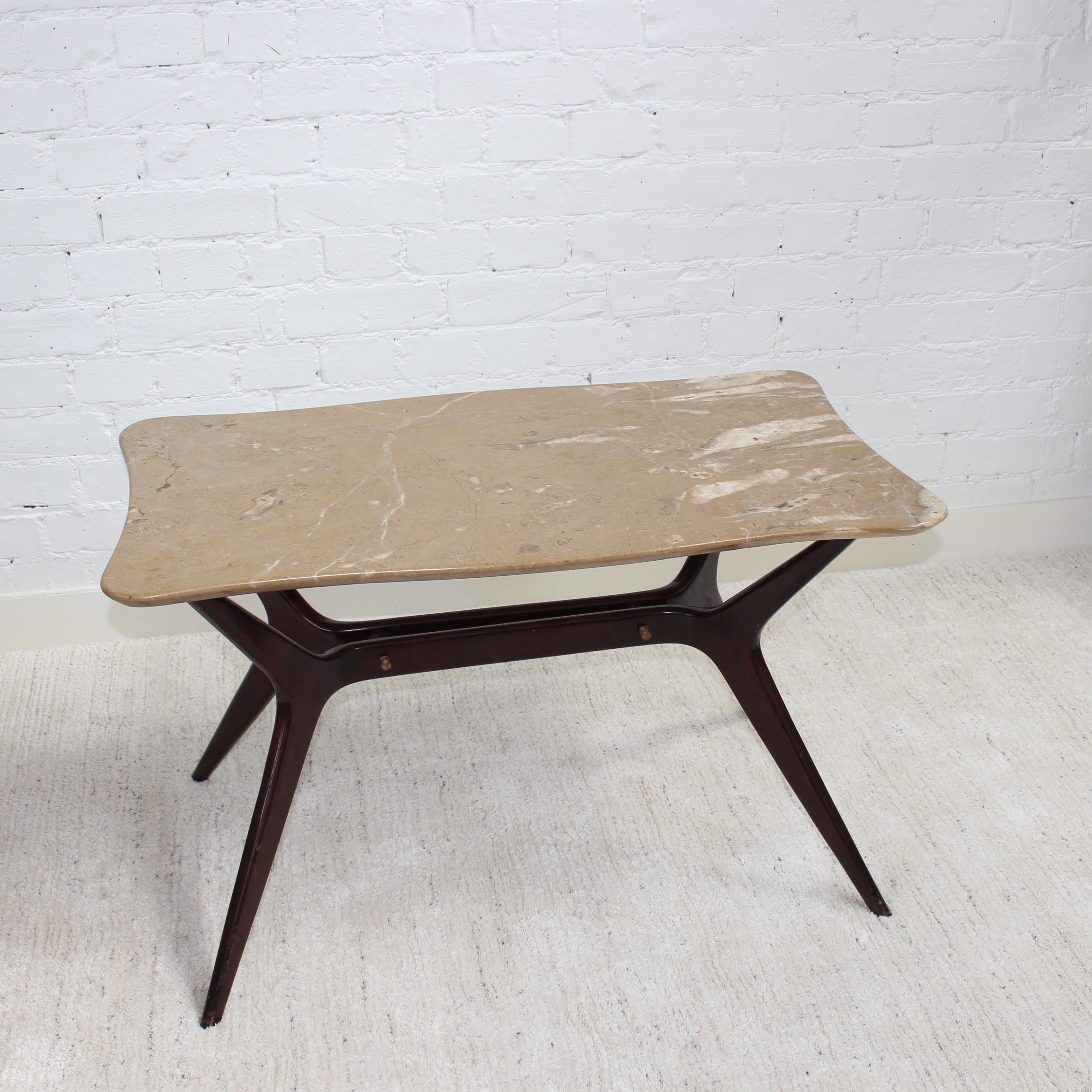 Mid-century Italian coffee table with marble top in the style of Ico Parisi (1950s). A tan with white highlights, rectangular (with curved ends) marble top sits upon a very stylish base consisting of Ico Parisi style wooden legs. The legs have a