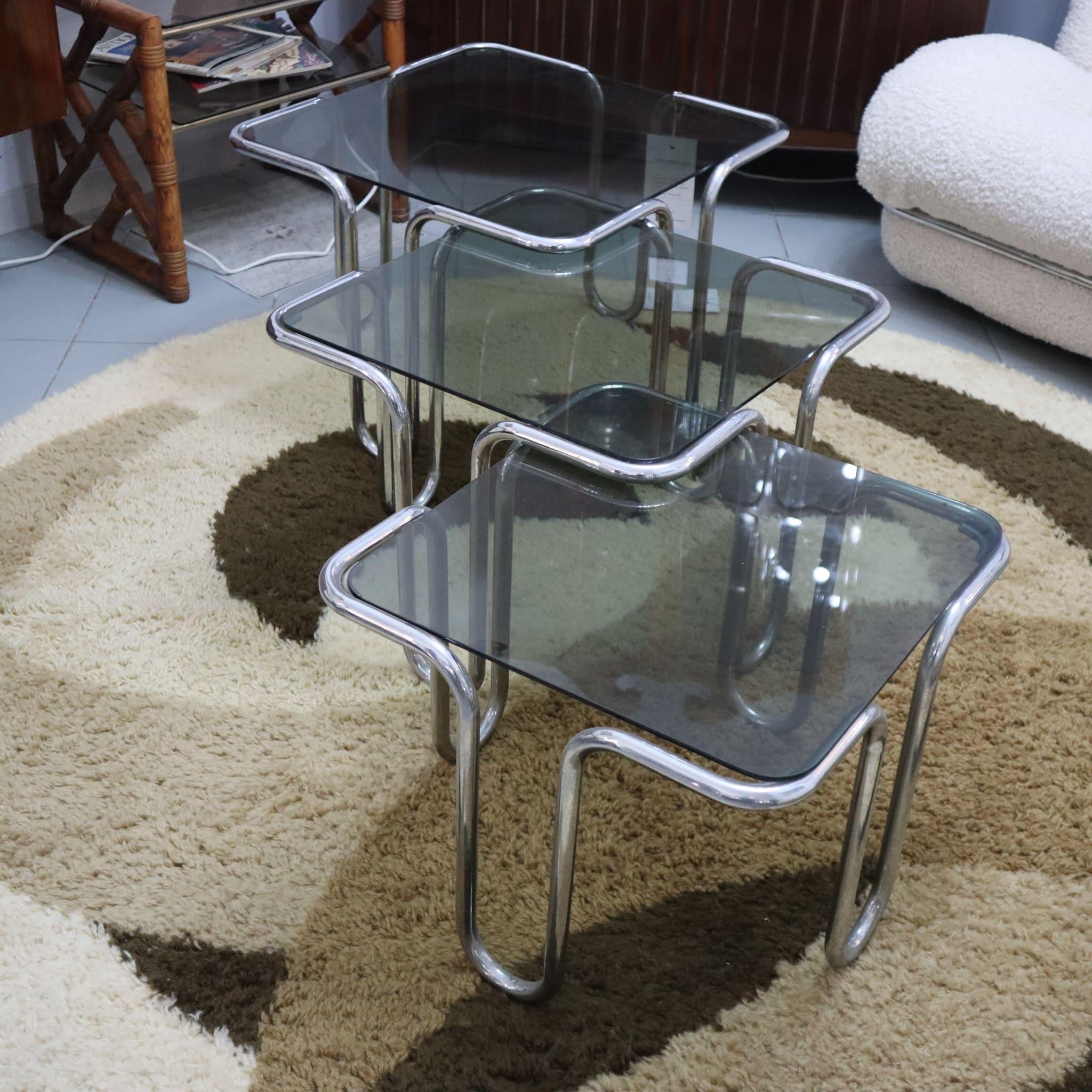 Lot de 3 tables basses italiennes du milieu du siècle dernier en verre fumé et métal chromé
Cet élégant ensemble de trois tables basses en acier chromé est un parfait mélange de design raffiné et de praticité. Dotées de plateaux en verre fumé, les