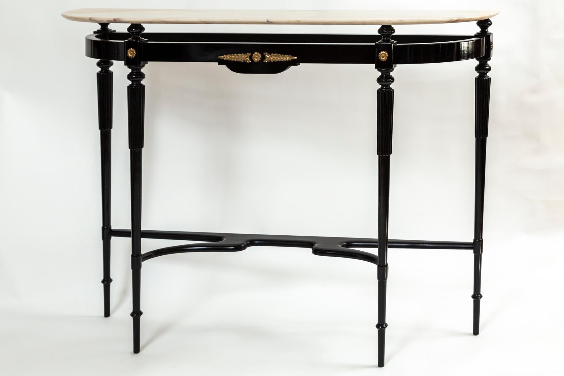 Modernist narrow demilune-shaped console with a floating onyx plateau on an ebonized black beech base comprised of fluted and rounded tapered legs joined by a stretcher and adorned sparsely with classical bronze mounts. Note lovely rounded shaping