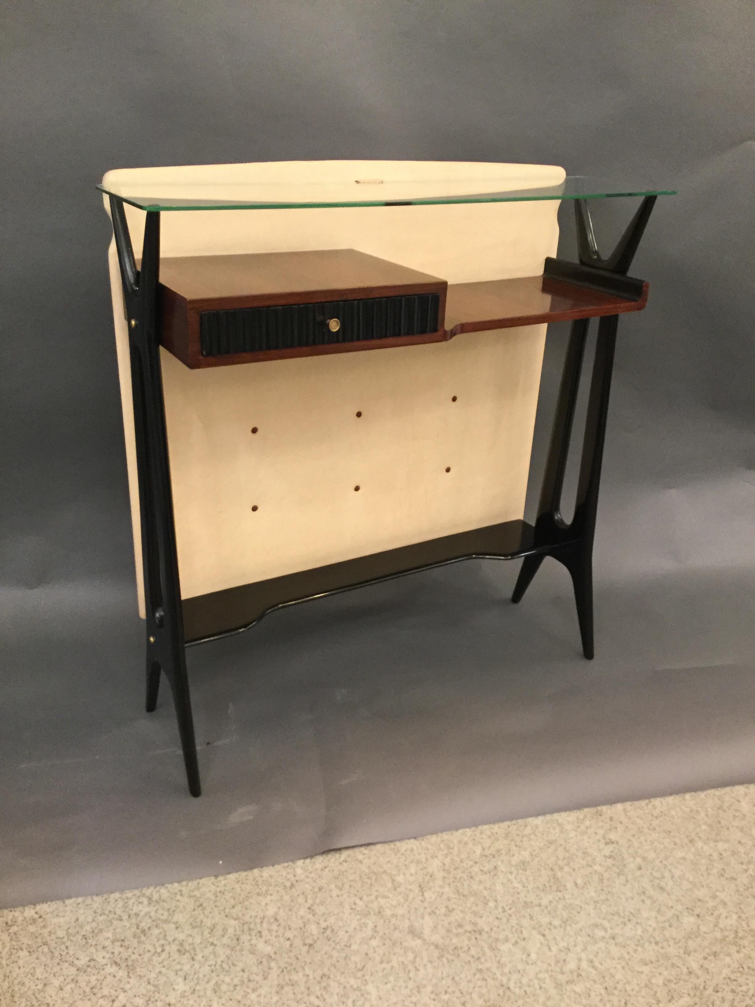 Elegant and rare 1940s Mid-Century Modern console, ebonized wood ivory faux leather lining and glass top
Re-polished, in excellent condition.


  