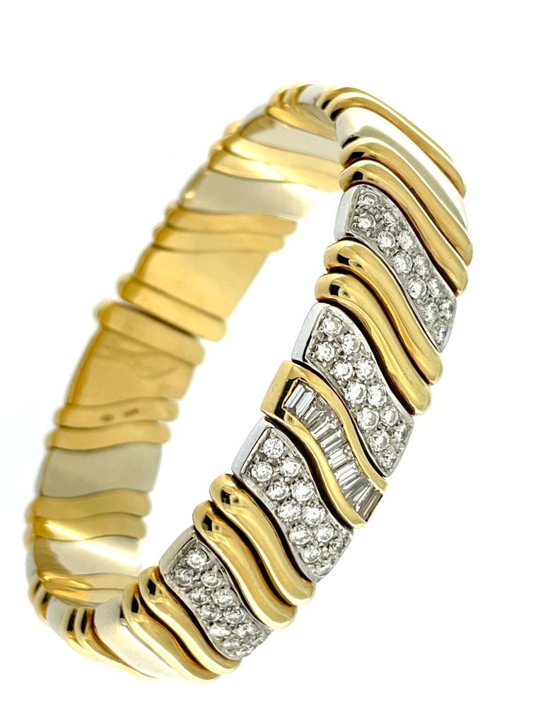 This Mid-Century Italian Cuff Bracelet is a stunning piece of jewelry that seamlessly blends elegance with geometric sophistication. Crafted with meticulous attention to detail, the bracelet is composed of a harmonious combination of yellow and