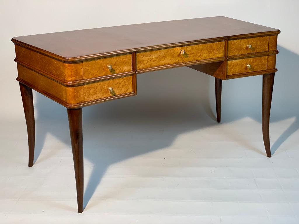 Italian desk with a fan shape, in the front five drawers two for each side smaller and a wider central one. This desk of the 40s in walnut and bird eyes maples has beautiful handles and brass key.
The listed width is the maximum of the back side,