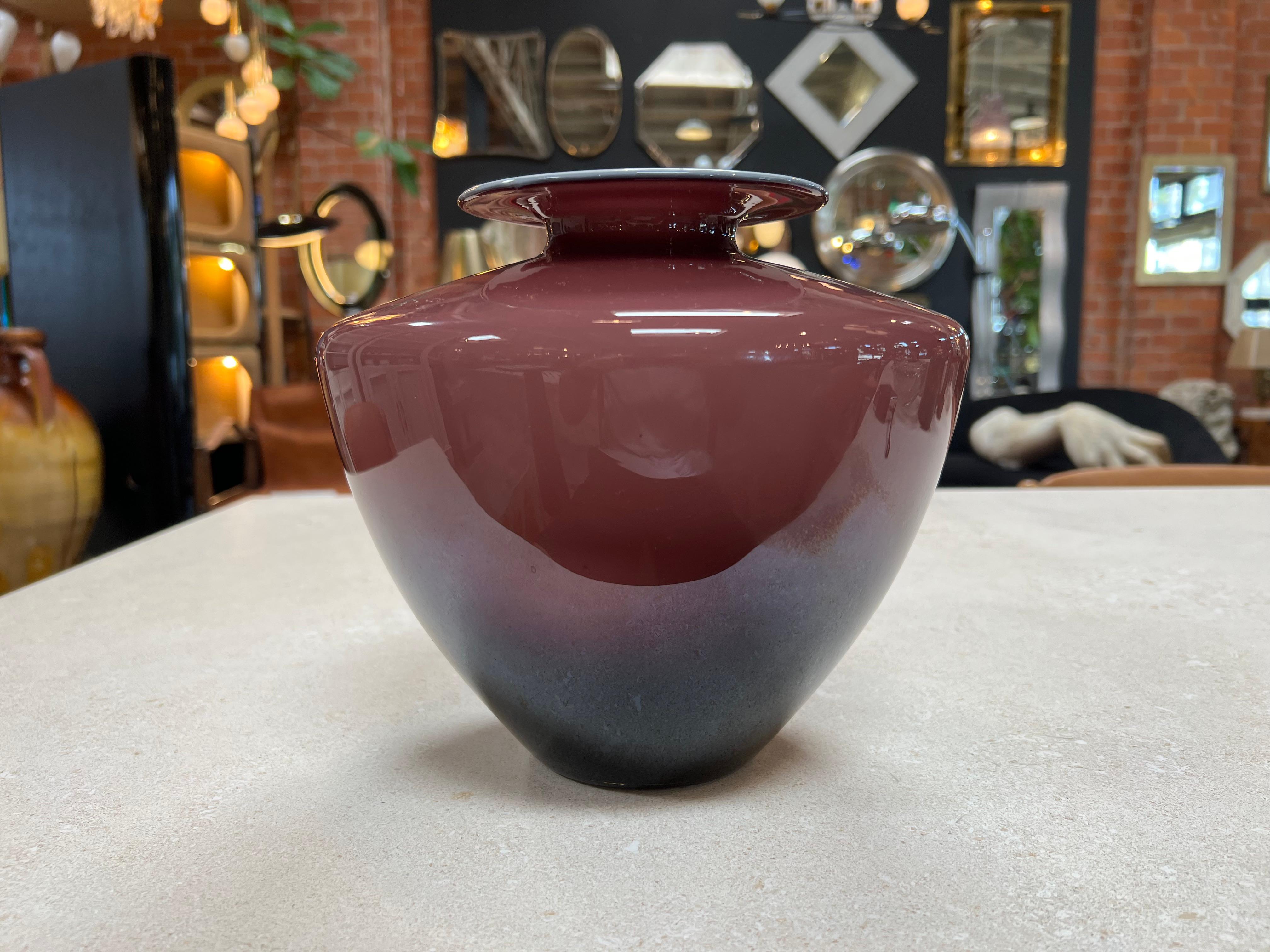 This small decorative purple vase made in Murano in 1980 is an exquisite piece of art crafted with precision and elegance. Its vibrant purple hue adds a touch of sophistication, while the intricate details and craftsmanship characteristic of Murano