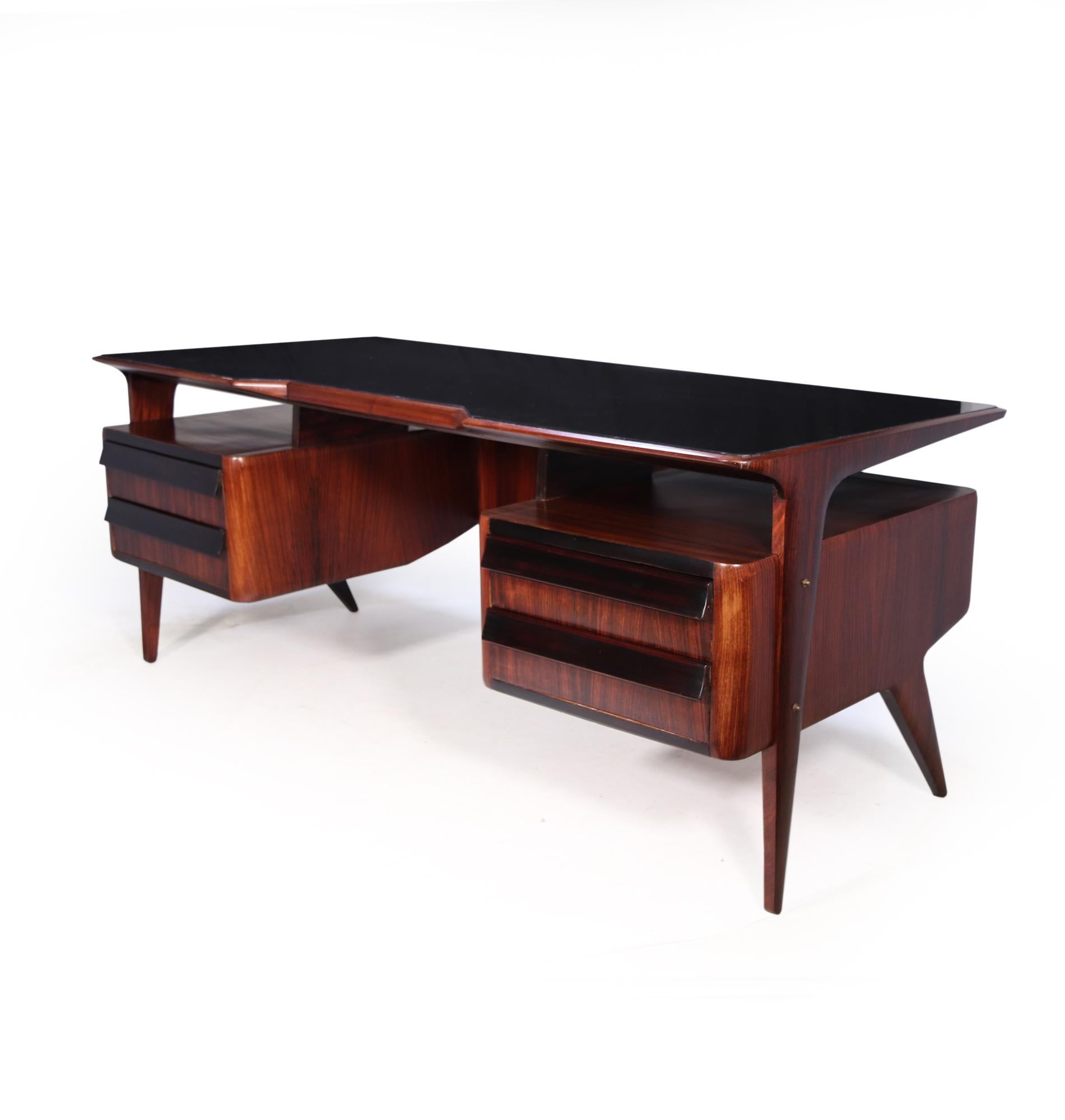 A stunning mid century executive Desk designed and produced in the 1950’s by Vittorio Dassi with four dovetail constructed drawers and shaped floating pedestal with black glass top

This desk has been restored where necessary and fully polished by