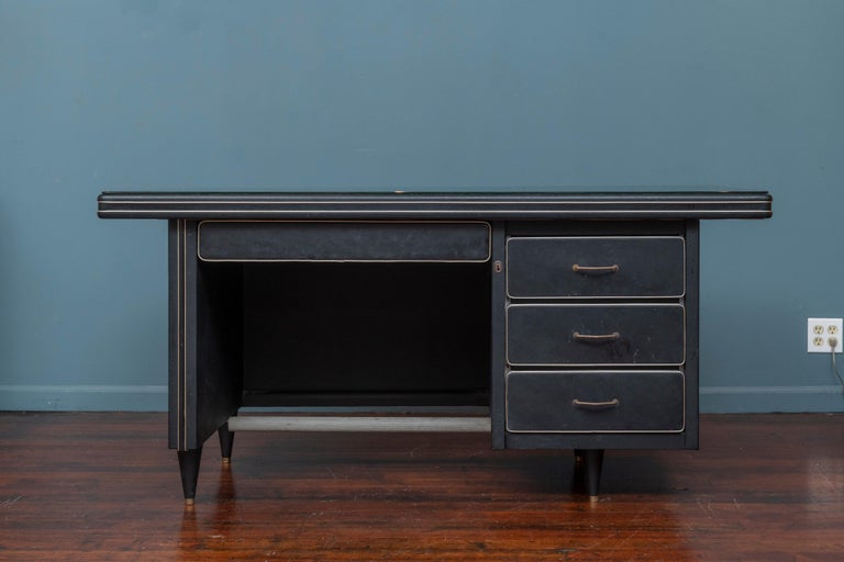 Mid-Century Modern Italian design desk with original black glass top. Chic looking desk from a prominent Beverly Hills Ca estate purchased for a movie mogul's daughter the theatre director of the Spreckels Theatre, San Diego. 
The body of the desk