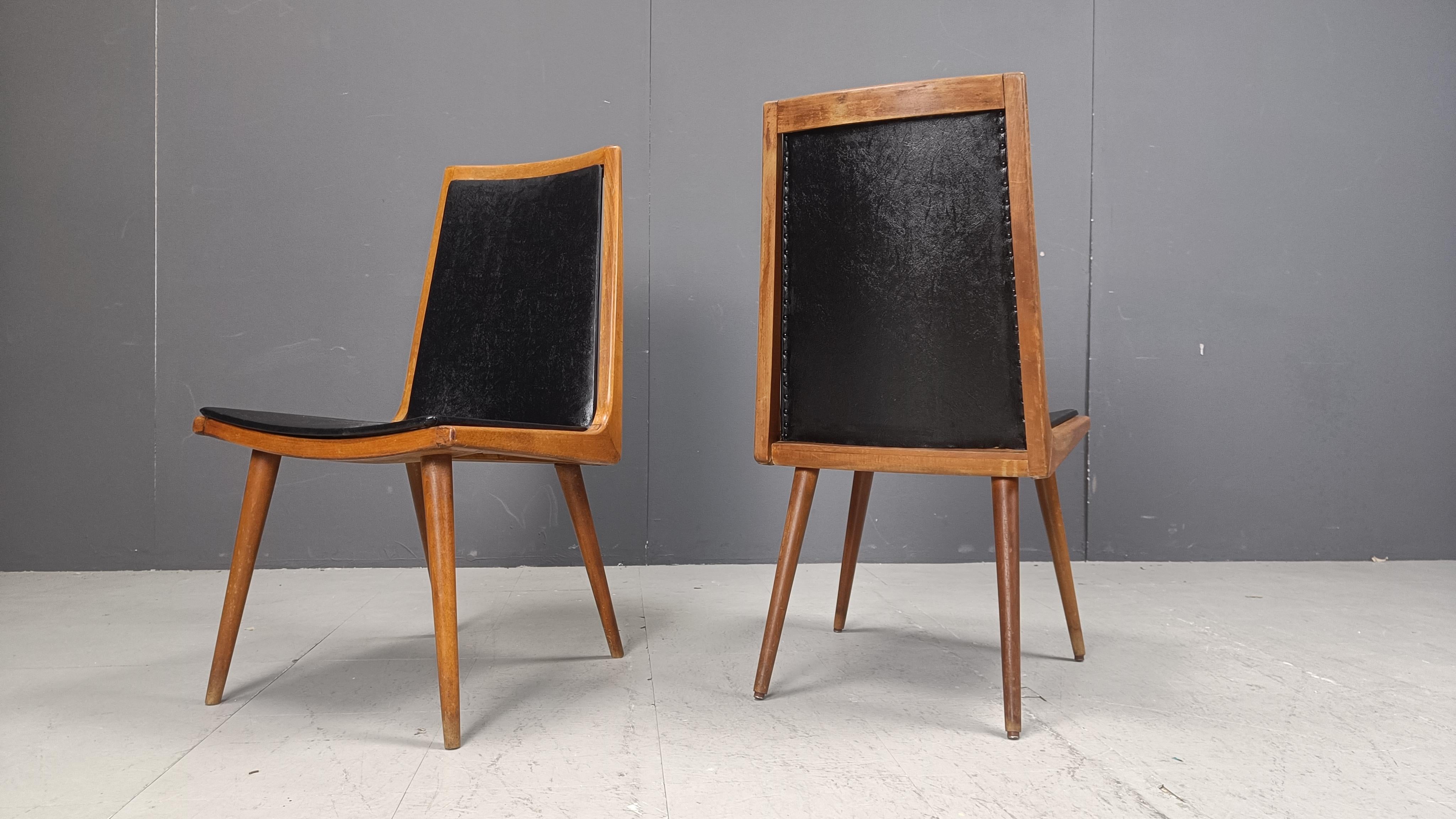 Mid century modern 'boomerang' design dining chairs with black skai upholstery.

Beautiful elegant design.

1950s - Italy

Good overall condition, normal age related wear.

Dimensions
Height: 92cm
Width: 46cm
Depth: 50cm
Seat height: 42cm

Ref.: