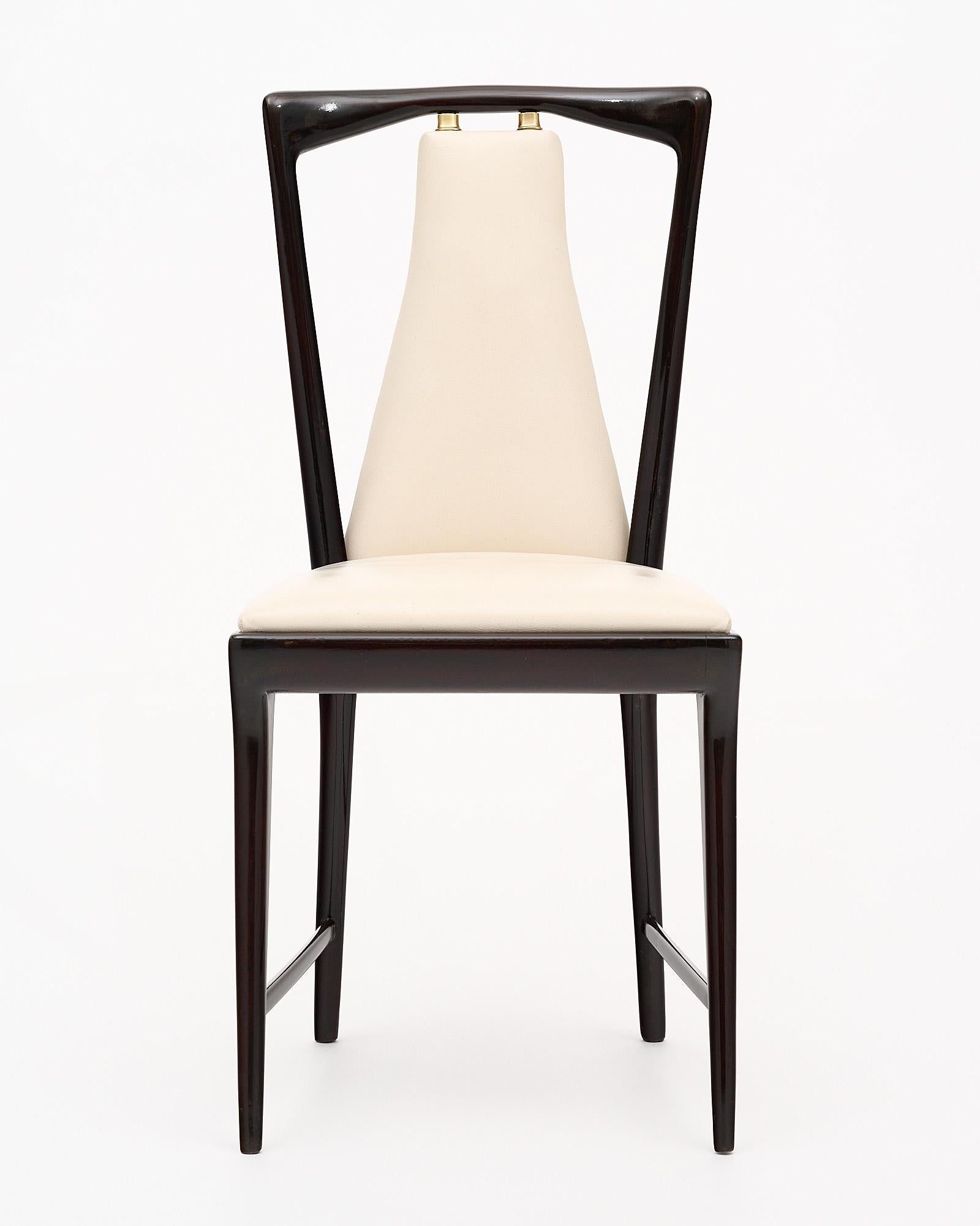 Set of 8 dining chairs from the Italian Modernist period by iconic designer Osvaldo Borsani. Made of French polished mahogany, these stylish and comfortable chairs feature their original vinyl upholstery and gilt brass accents.
