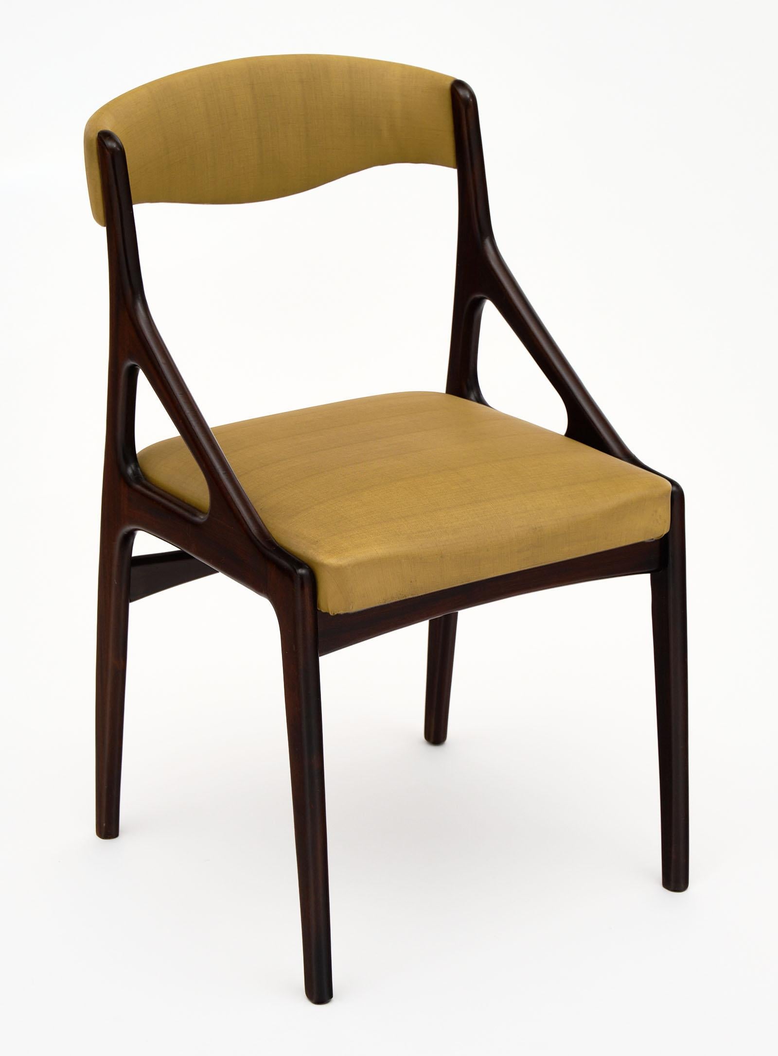 Midcentury Italian dining chairs in a modernist style. Each is made of mahogany finished with a lustrous French polish. The original green/gold vinyl upholstery is in good vintage condition with only minor surface wear consistent with age and use.
