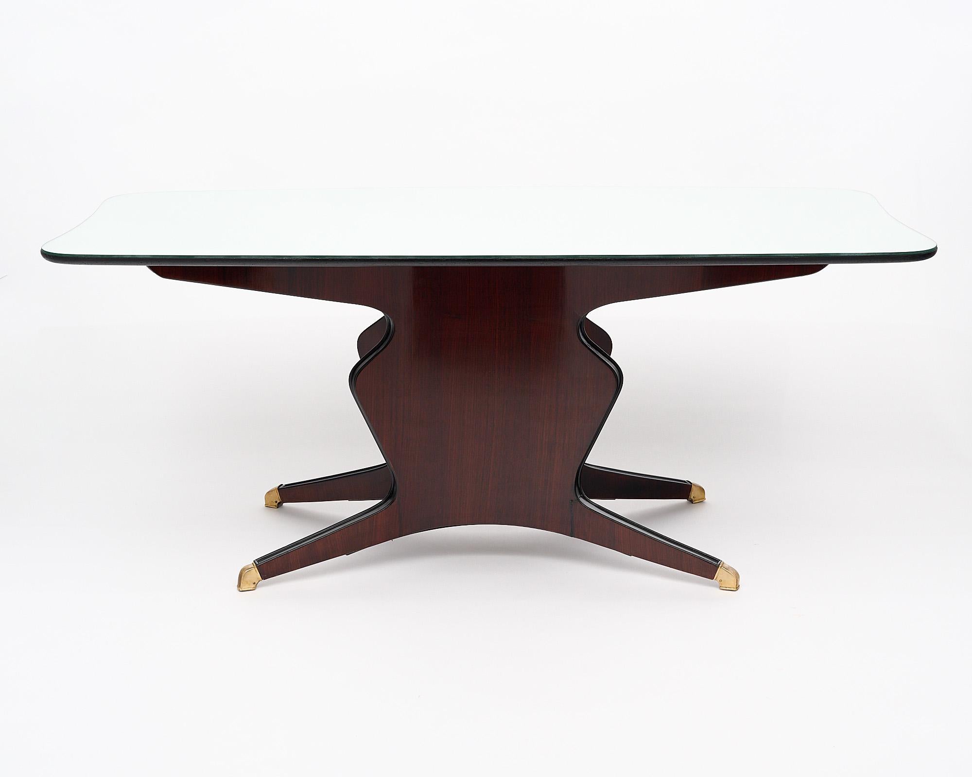 Dining room table, Italian, by iconic designer Osvaldo Borsani. The top is mirrored while the uniquely shaped base, which sits on four legs with four bronze feet, is finished in a lustrous Museum quality French polish.