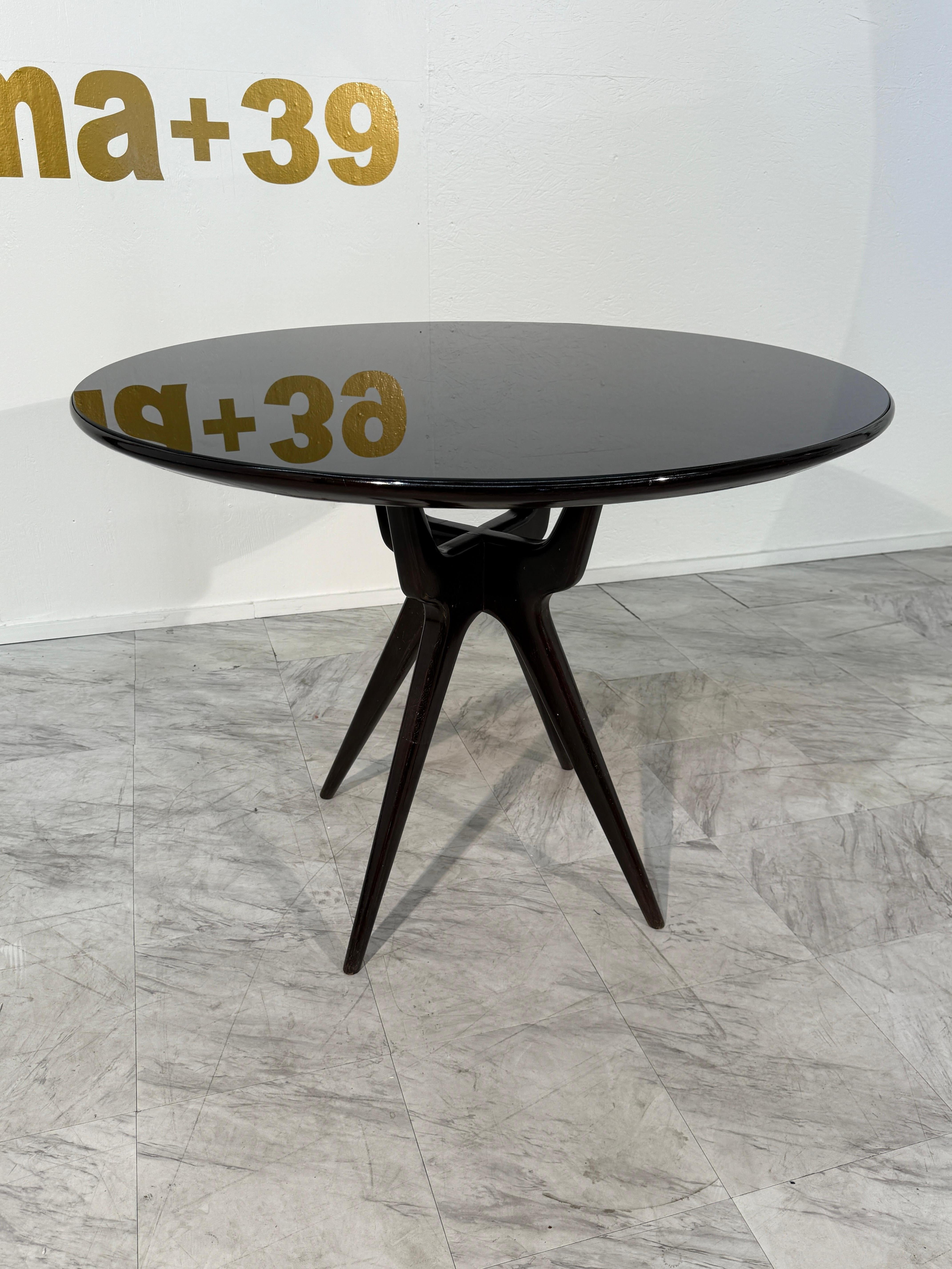 Designed by Osvaldo Borsani, this mid-century Italian dining table is crafted in richly ebonized wood, featuring a round, reflective top that heightens its moody, sculptural appeal. The surface plays beautifully with light, adding depth, dimension,
