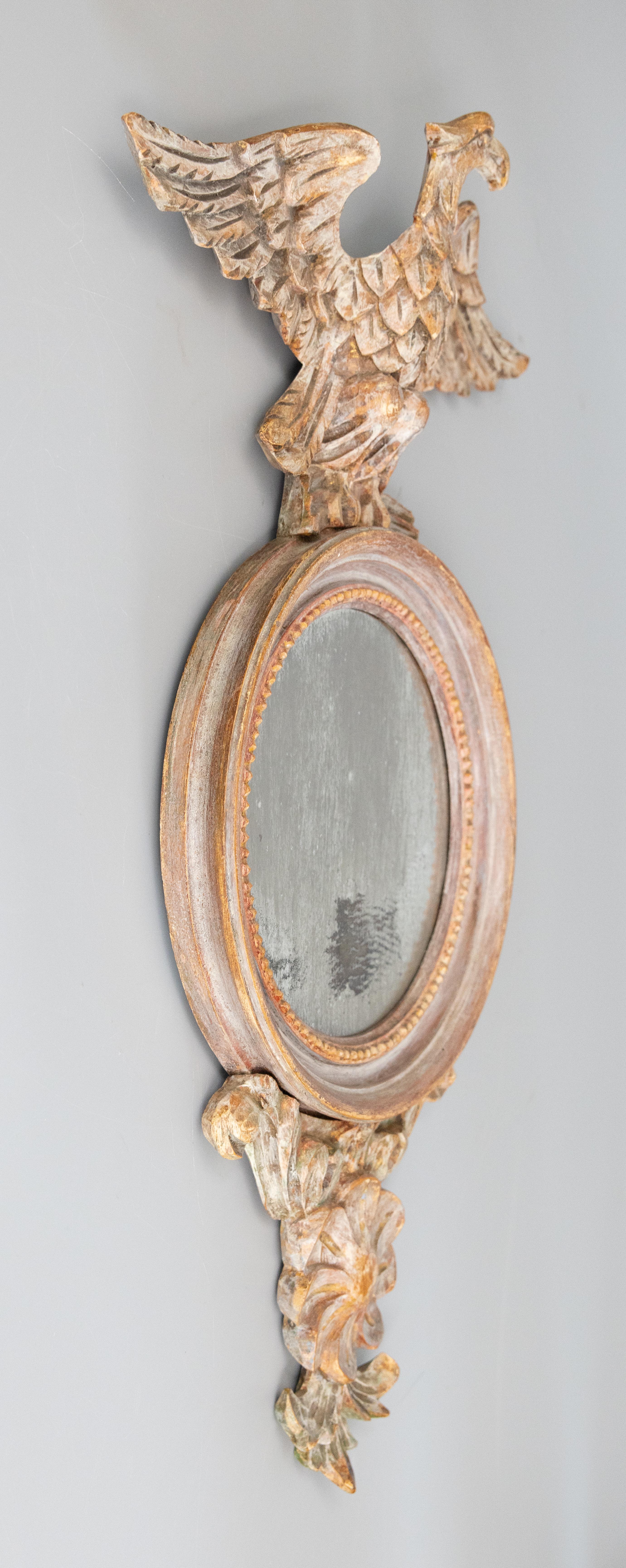 Un fabuleux miroir à œil de bœuf en bois chaulé de style fédéral italien du milieu du siècle dernier, vers 1960. Ce magnifique miroir présente une belle finition chaulée ou vieillie à la chaux et est décoré d'une crête d'aigle sculptée, d'un accent