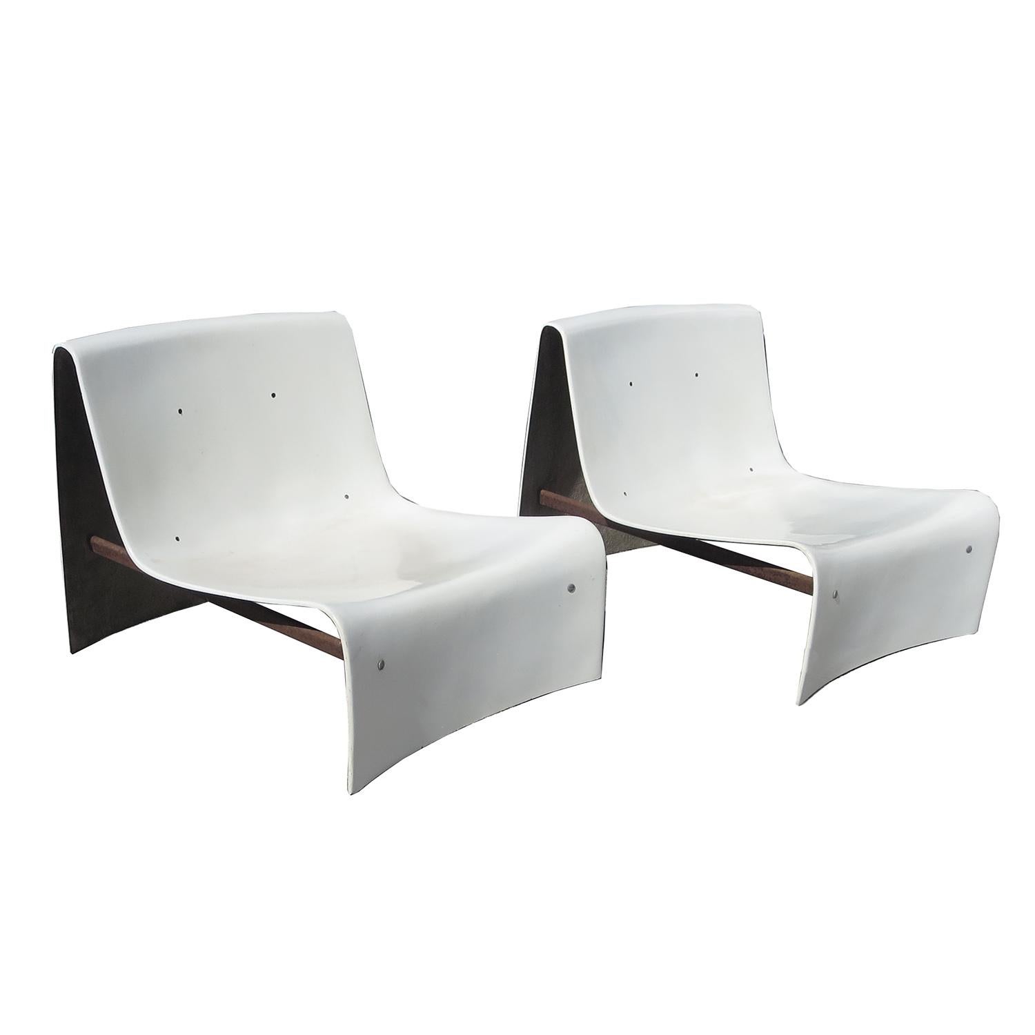 These stylish chairs are Italian in origin, by an unknown designer. The shells are molded fiberglass, with twin steel bar supports underneath for stability. The chairs are all original, and show natural wear, consistent with age.