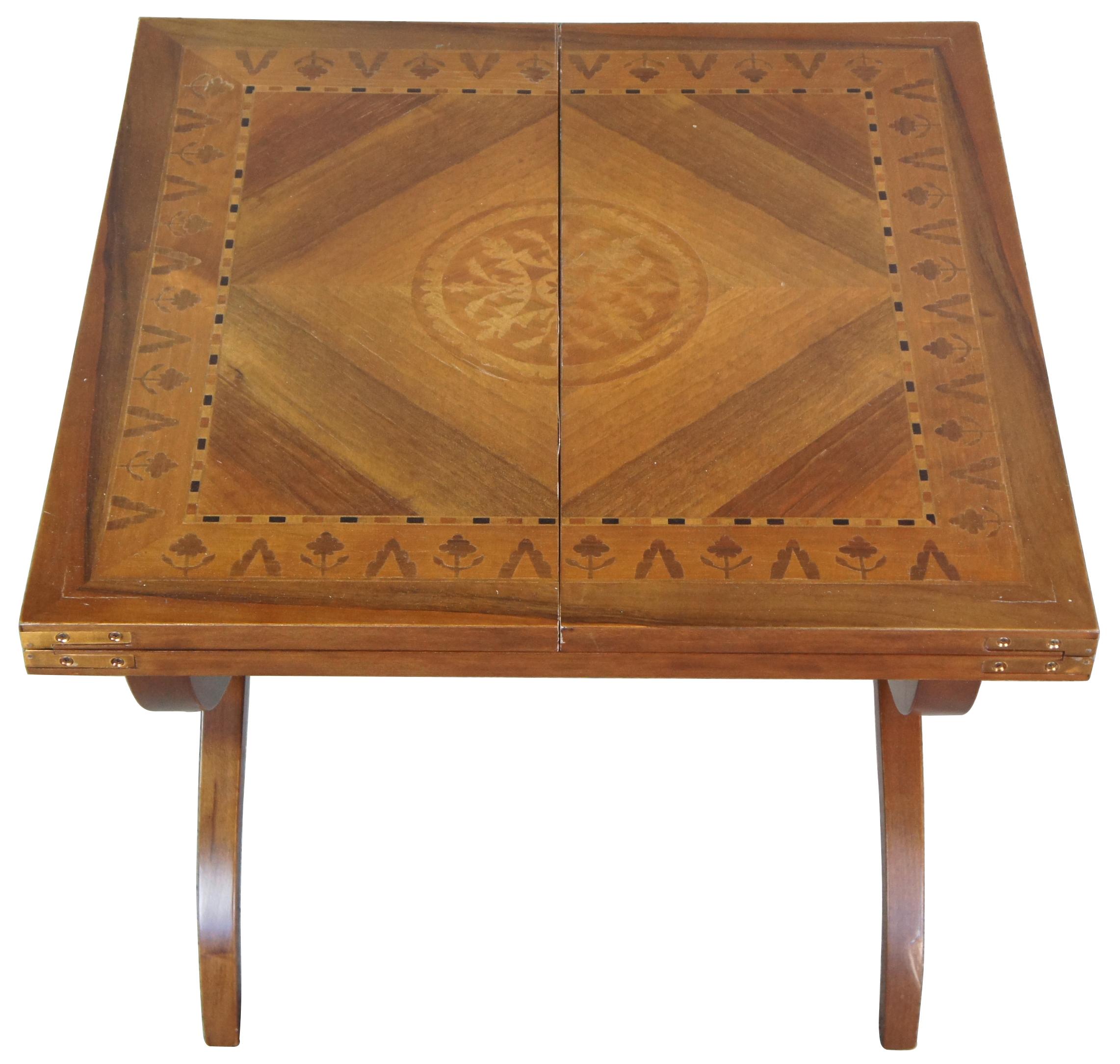 Mid 20th century flip top marquetry coffee table. Made in Italy style 8506 featuring square or rectangular form with floral and geometric matchbook inlays, central medallion and serpentine X base with turned stretcher.

Provenance: Estate of Carol