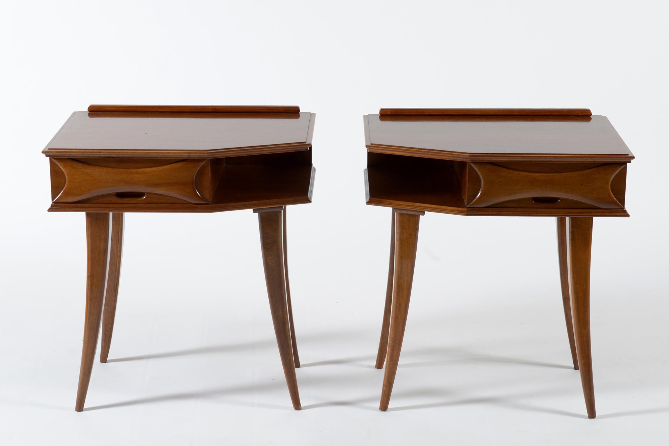 Solid walnut midcentury nightstands or side tables, made in Florence in the 1950s on one side a drawer with carved handle in solid wood and on the other side open compartment for books and magazines. Four slender saber legs.
     
