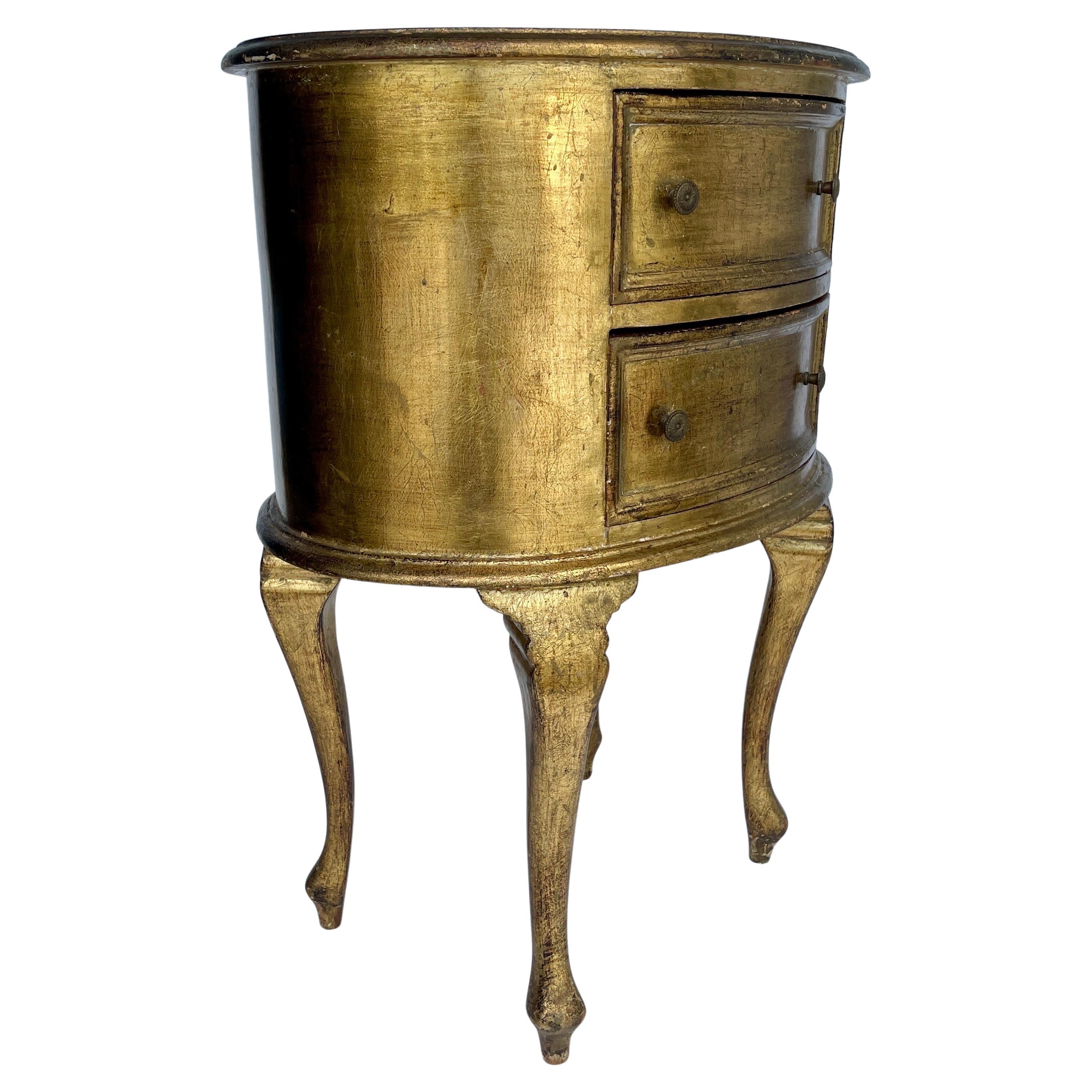 Oval 1950's Florentine Gilt Bedside Accent Side Table, Italy

Charming Mid-Century modern two-drawer side table from the 1950's. This piece has original gilt gold finish and certainly elegant standing alone or next to a sofa or used in a bedroom.