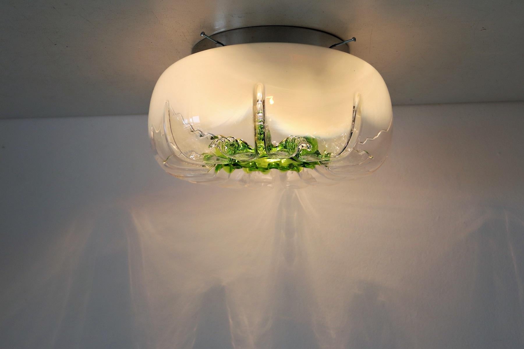 Gorgeous flush-mount light in green - transparent Murano glass, fixed with screws to an aluminium base.
The flush mount can be mounted to ceiling as well to the wall.
Designed in the 70s in the style of Angelo Brotto, and made in Italy.
Very good