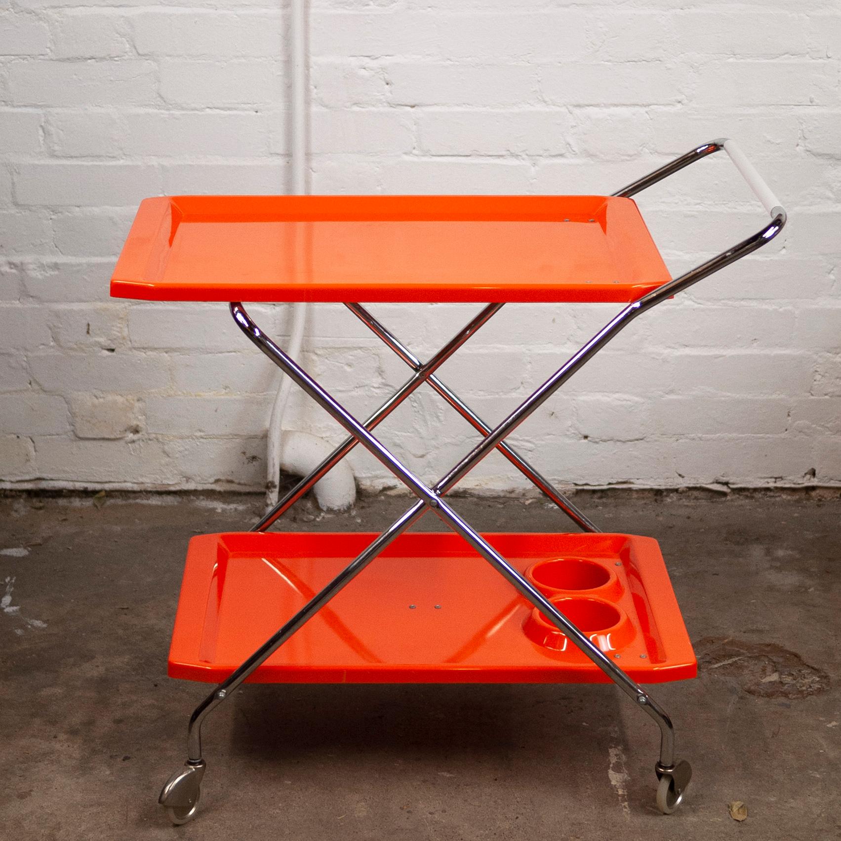 A mid-century orange plastic and chromed metal bar folding cart.

Design Period - 1960 to 1969

Country of Manufacture - Italy

Style - Mid-Century

Detailed condition - good with minimal defects.

Restoration and damage details - Light