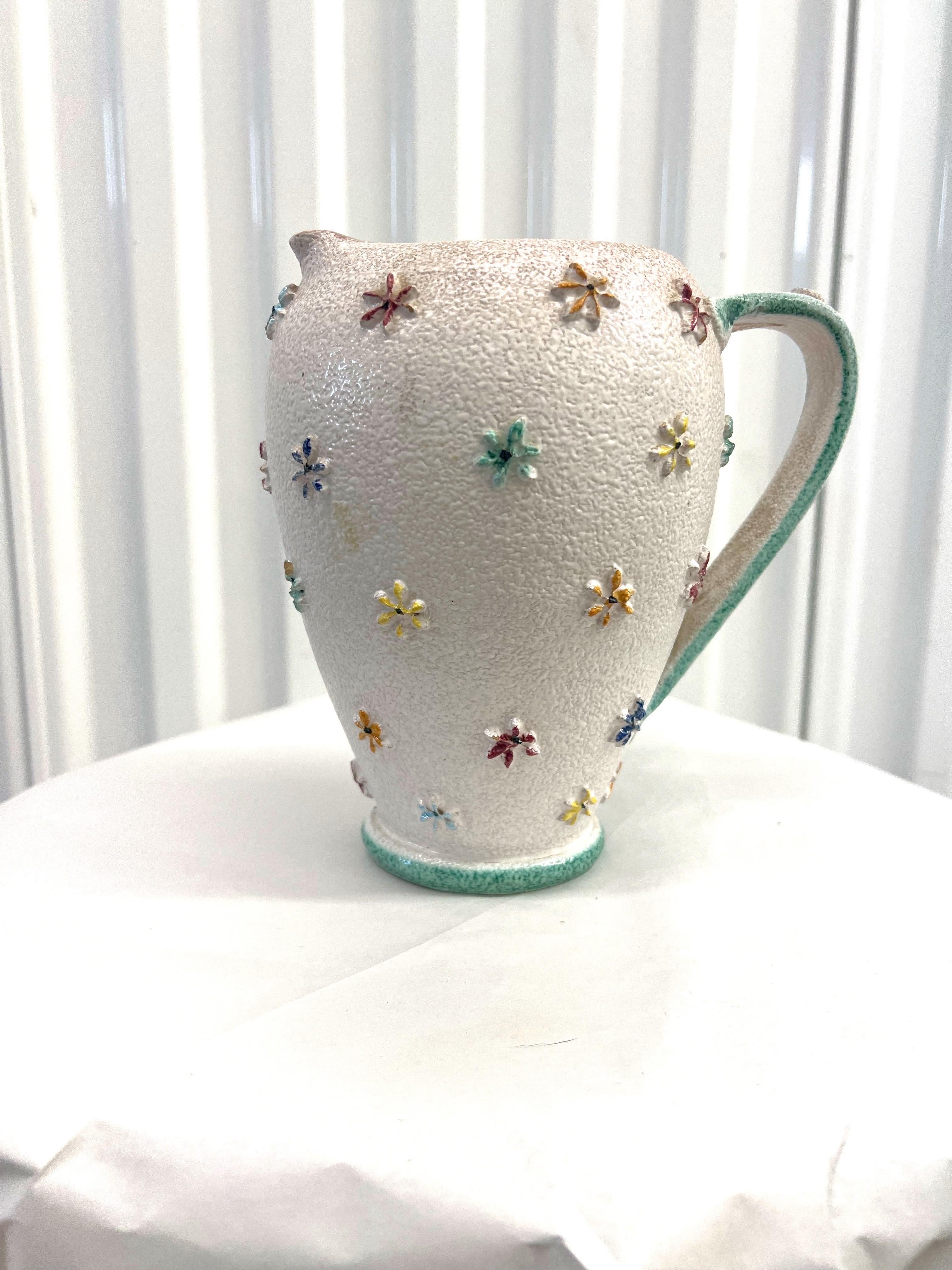 A stunning and feminine white textured Italian vase with a floral relief and very interesting handle.  This piece is marked “Italy” and numbered on the bottom.  This is well documented online to be Fratelli Fanciullacci.  A very collectible piece of