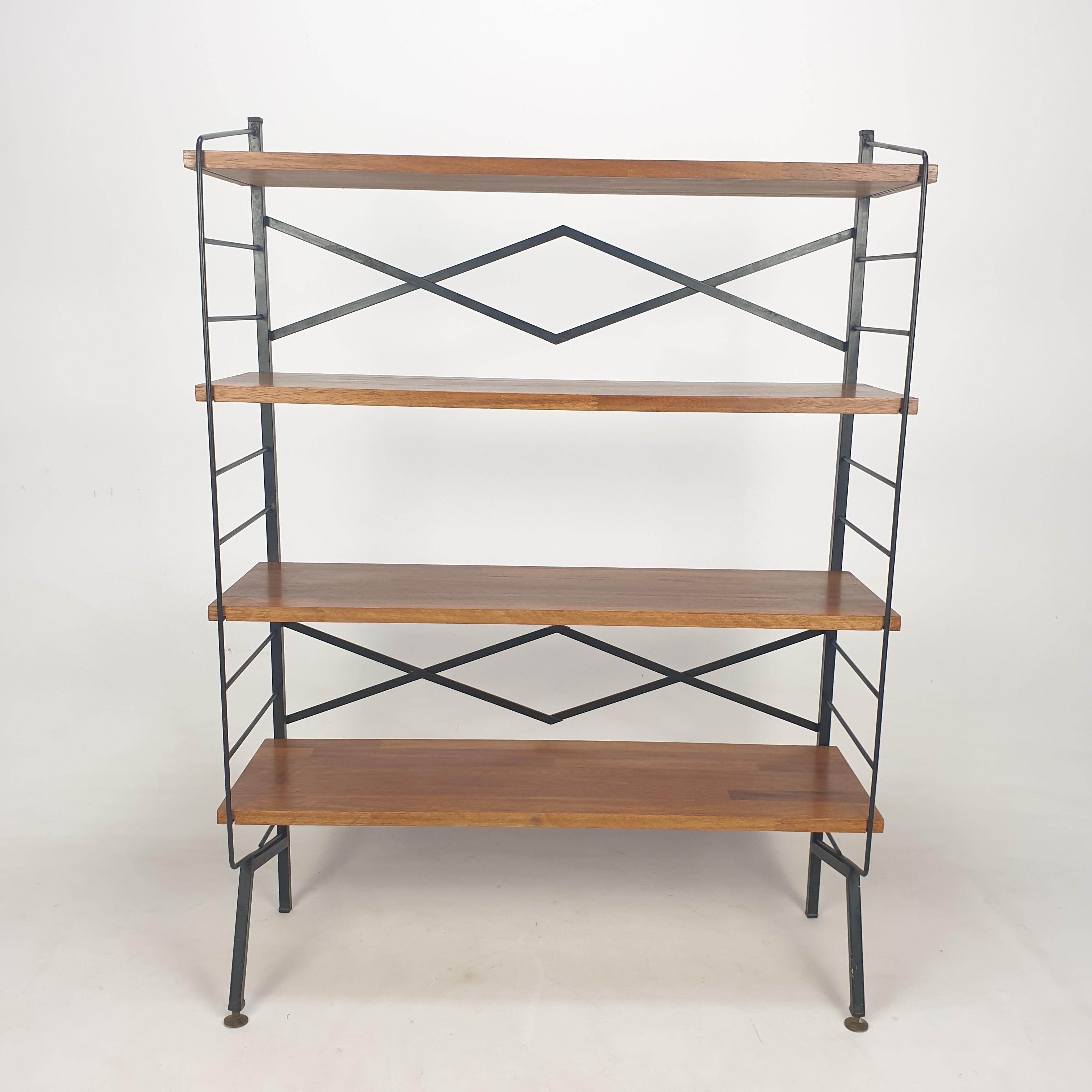 Very nice free standing shelve system, fabricated in Italy in the 50's.

4 wooden shelves with a black painted metal system and brass feet.

It is very easy to disassemble with 8 screws.